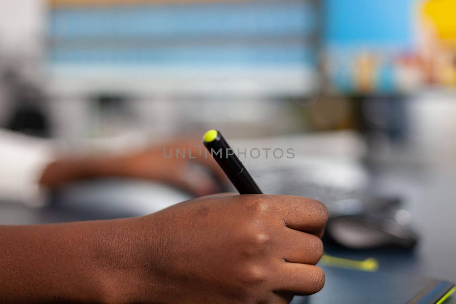 Close up of black photo designer editing customer image with stylus pencil, illustrator drawing on graphics tablet. Hand of african woman editor retouching assets sitting in creative agency office