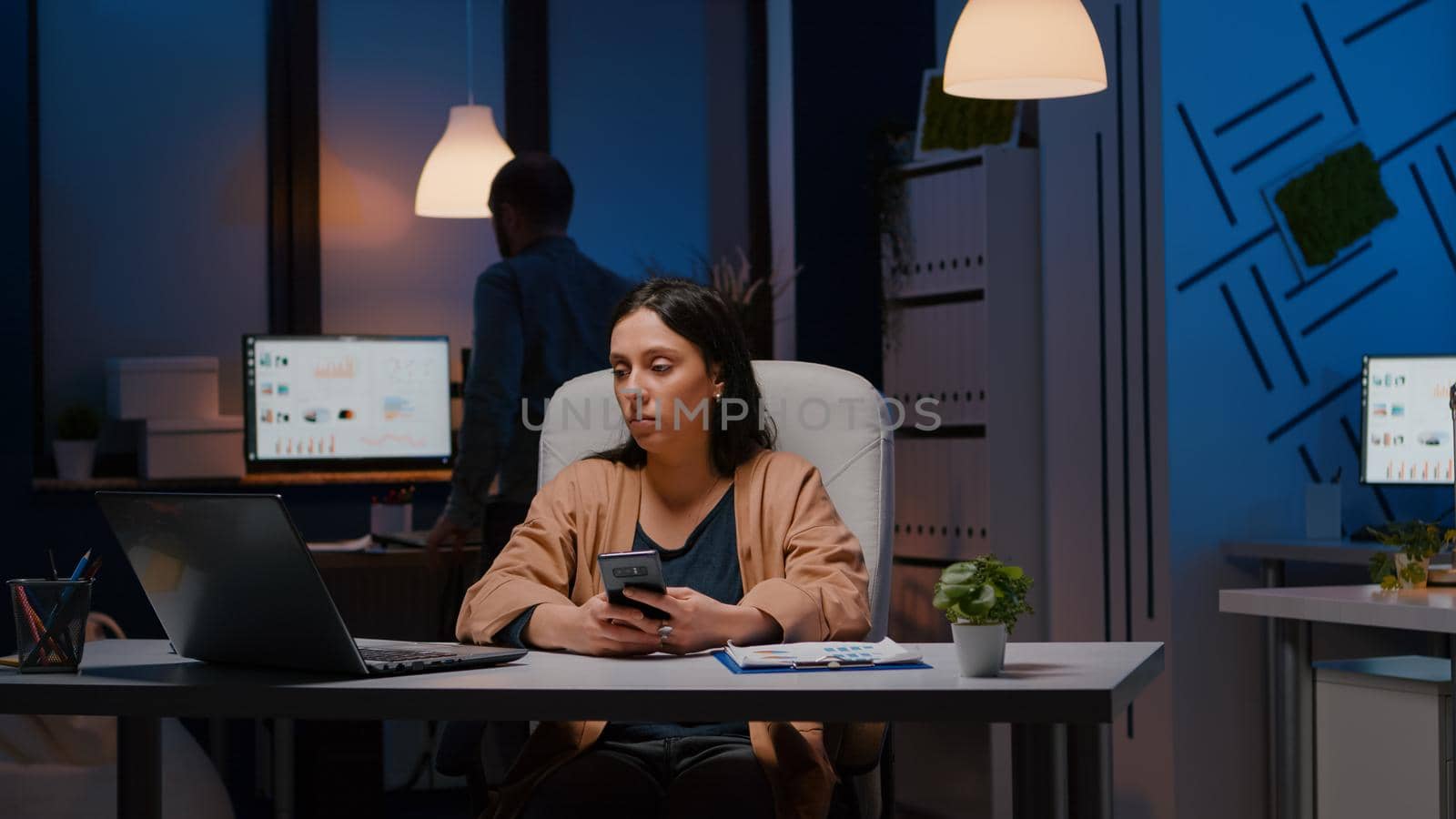 Businesswoman working in start-up business company office sitting at desk by DCStudio