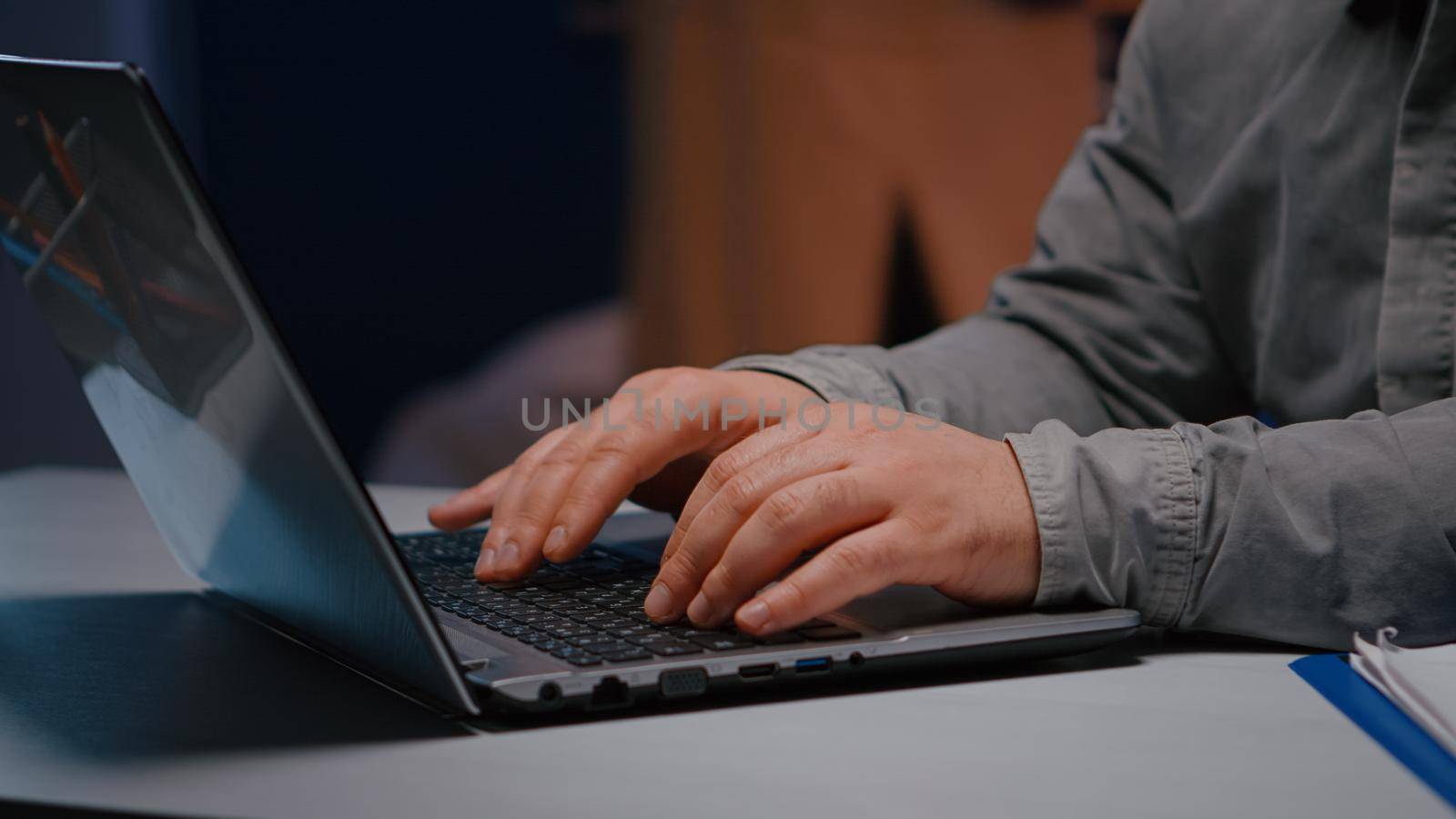 Close-up of businessman hands on keyboard sitting at desk table in startup company office browsing economic ideas on internet. Entrepreneur typing financial statistics answering business email