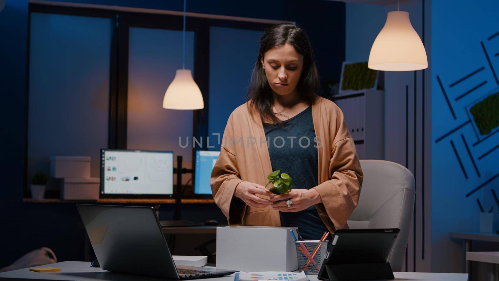 Dismissed unhappy businesswoman packing company stuff putting in white box by DCStudio