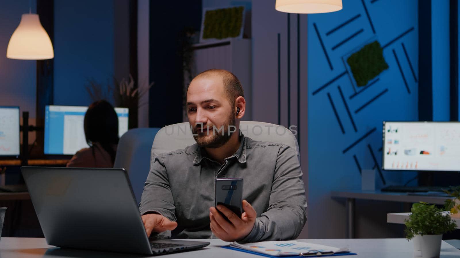 Entrepreneur man chatting with company teamwork on phone planning management meeting discussing economic strategy during teammeeting videocall. Businessman working late at night in startup office