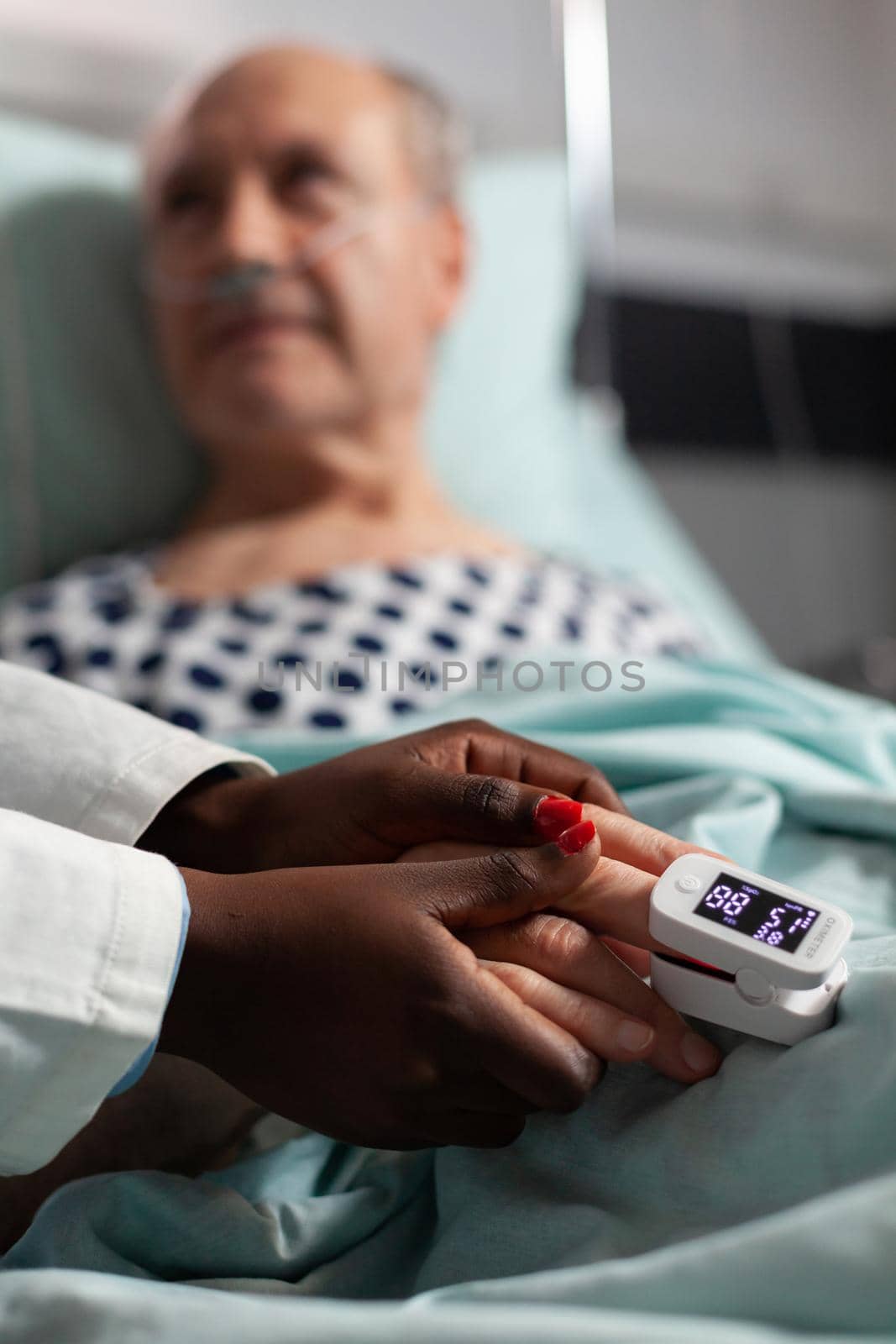 Caring friendly african american doctor holding senior patient hand by DCStudio