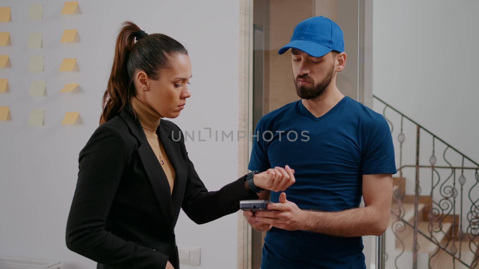 Cheerful delivery guy bringing takeaway food meal in startup company office during lunchtime by DCStudio