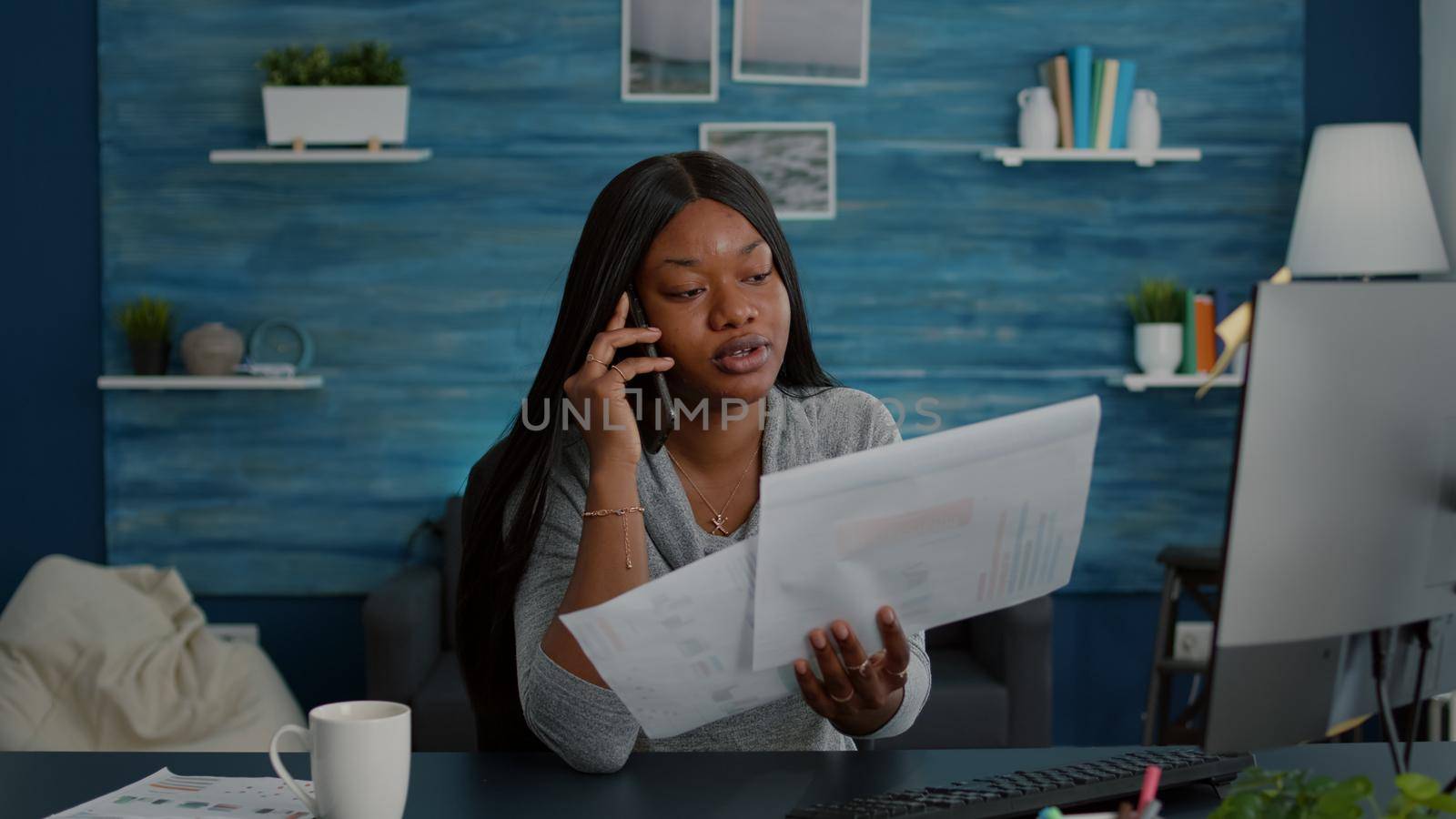 Upset student sitting at desk table in living room explaining high school homework by DCStudio