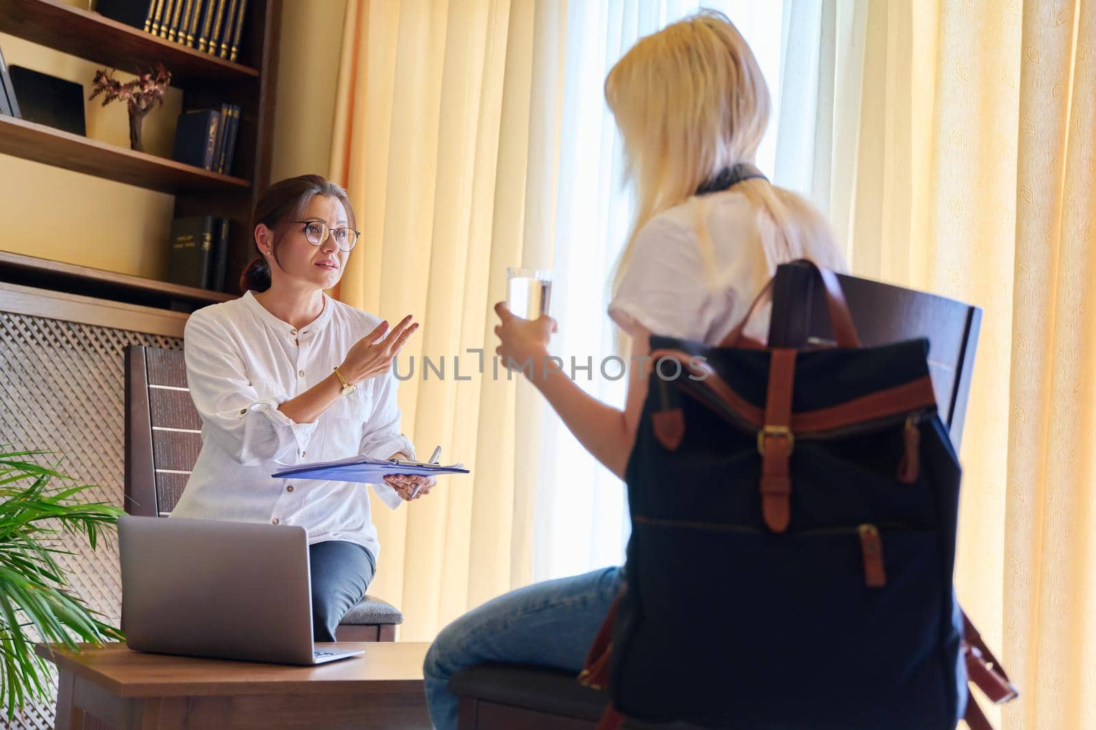 Session of female psychologist and girl teenage student in doctor's office. Consultation, professional assistance of terapist counselor for children and adolescents. Psychology, therapy, psychotherapy