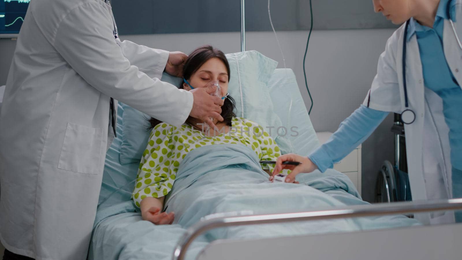 Medical team checking heartbeat of sick woman during respiratory healthcare by DCStudio