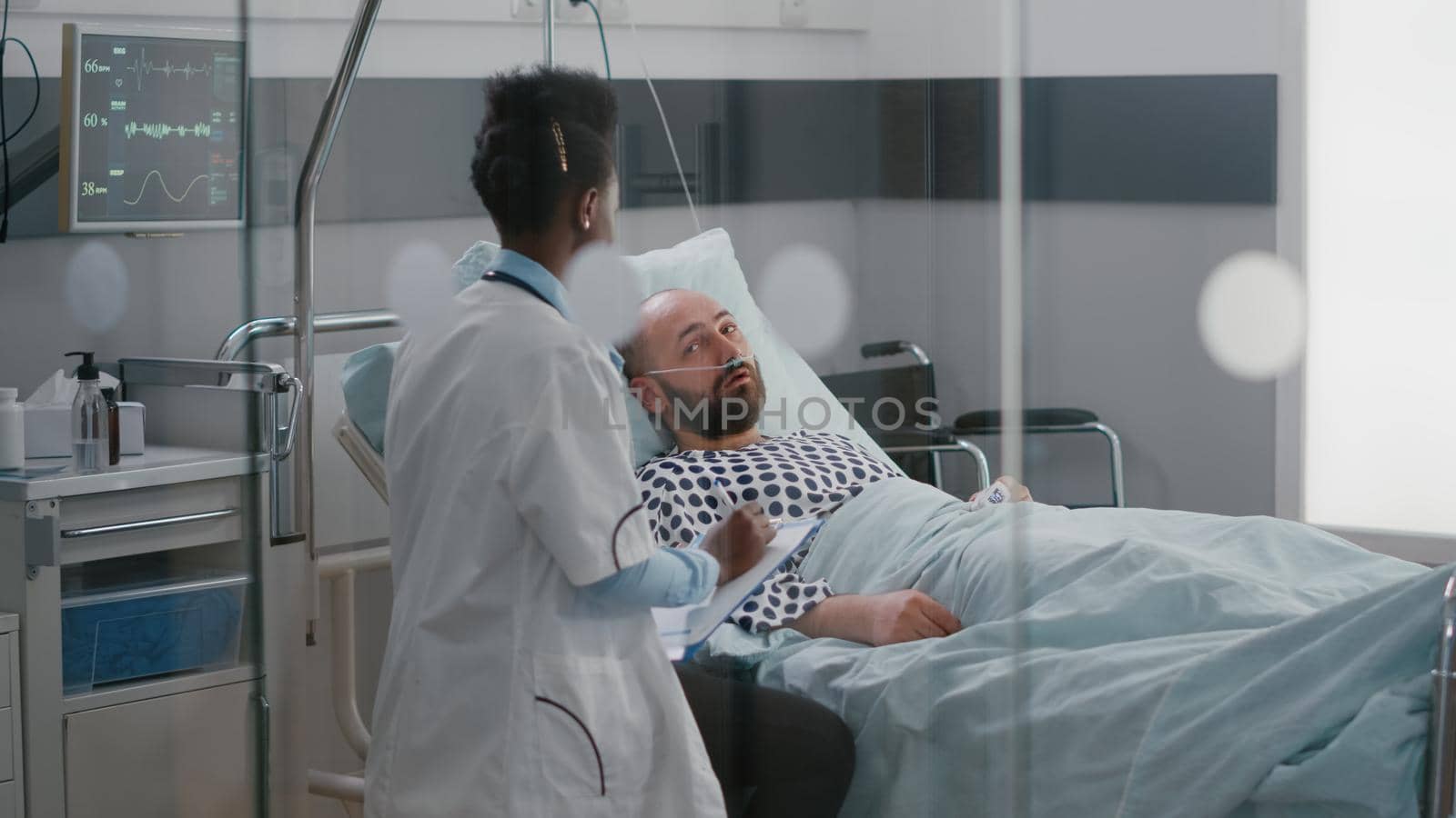 Afro american doctor checking sick man monitoring sickness symptom by DCStudio