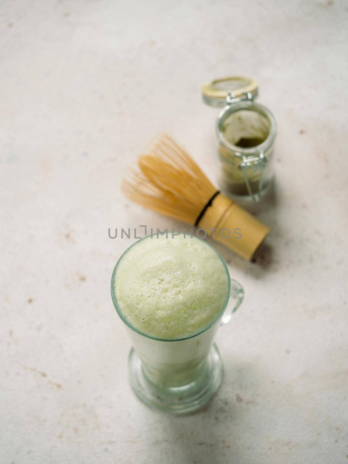 Green foam texture of matcha latte, close up by fascinadora