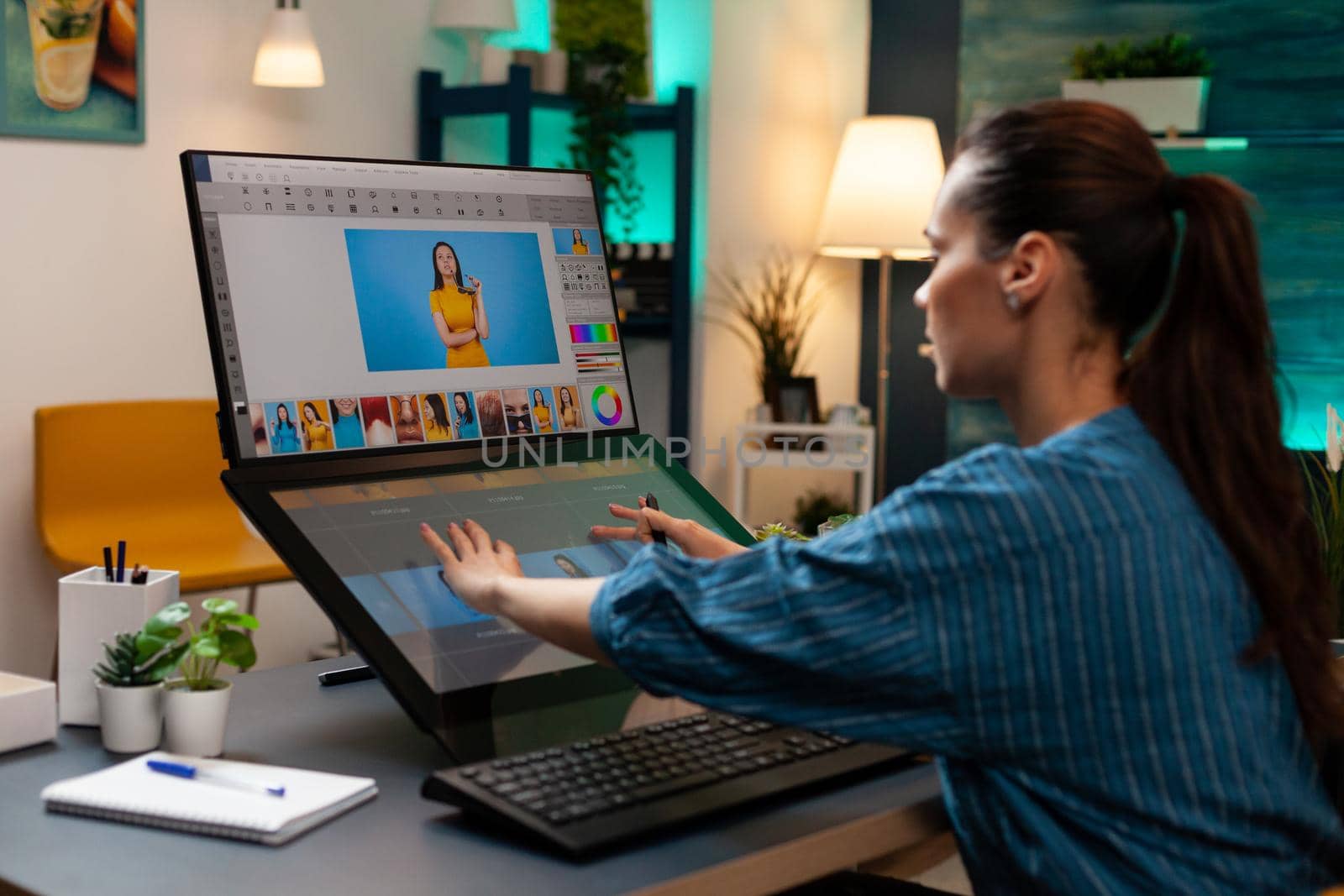 Studio editor doing retoucher work on touch screen computer monitor for occupation. Artist sitting at professional desk working with modern technology photography software and stylus