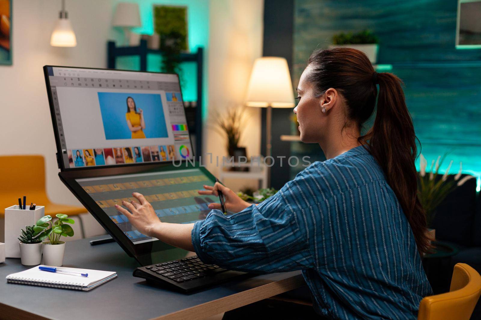 Photo editor artist doing touchpad work on retouching image using stylus and monitor screen for editing design on digital computer. Photographer woman working at production workplace