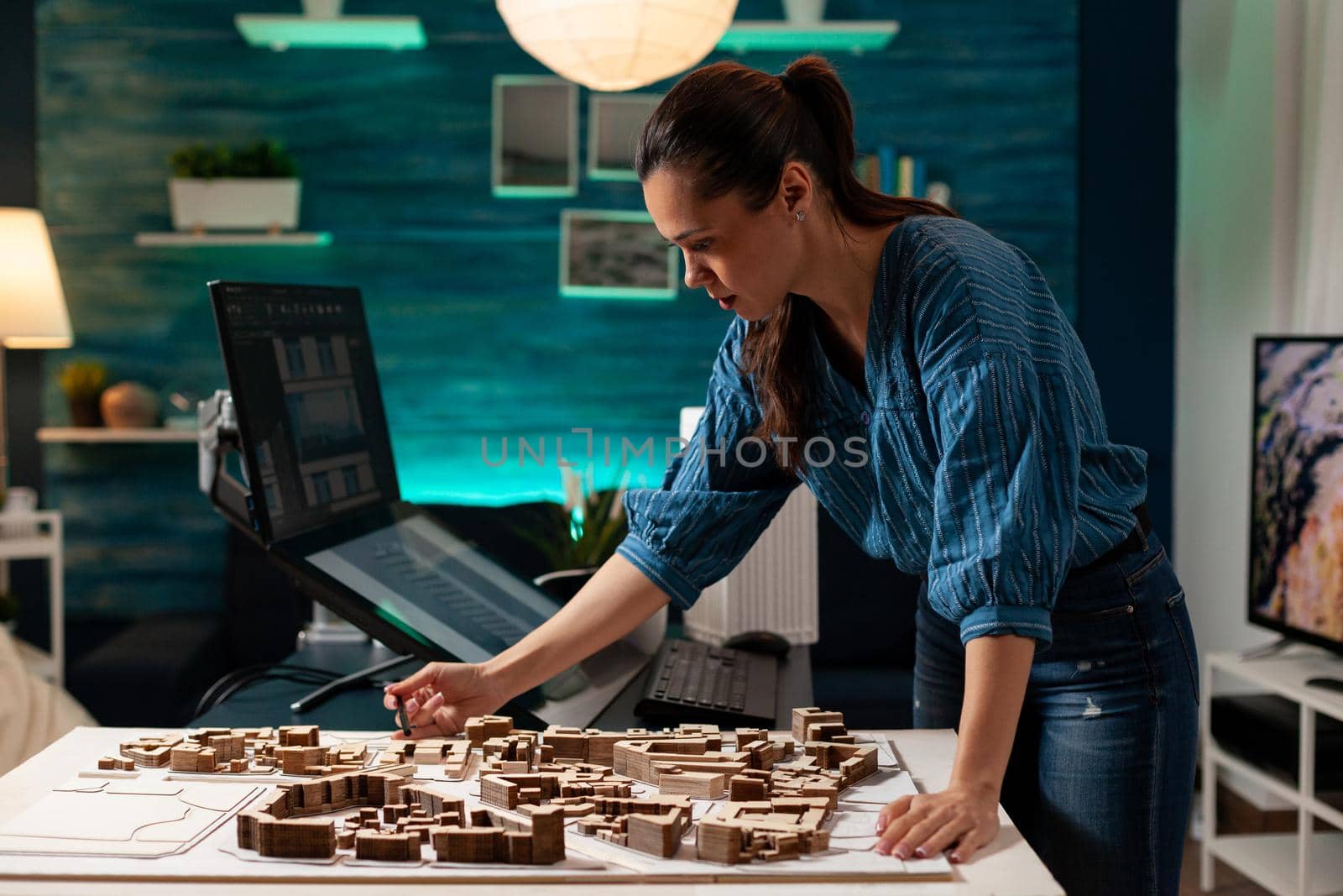 Professional architect standing at maquette table analyzing building model plan for construction project concept. Woman designer engineering architectural renovation business layout