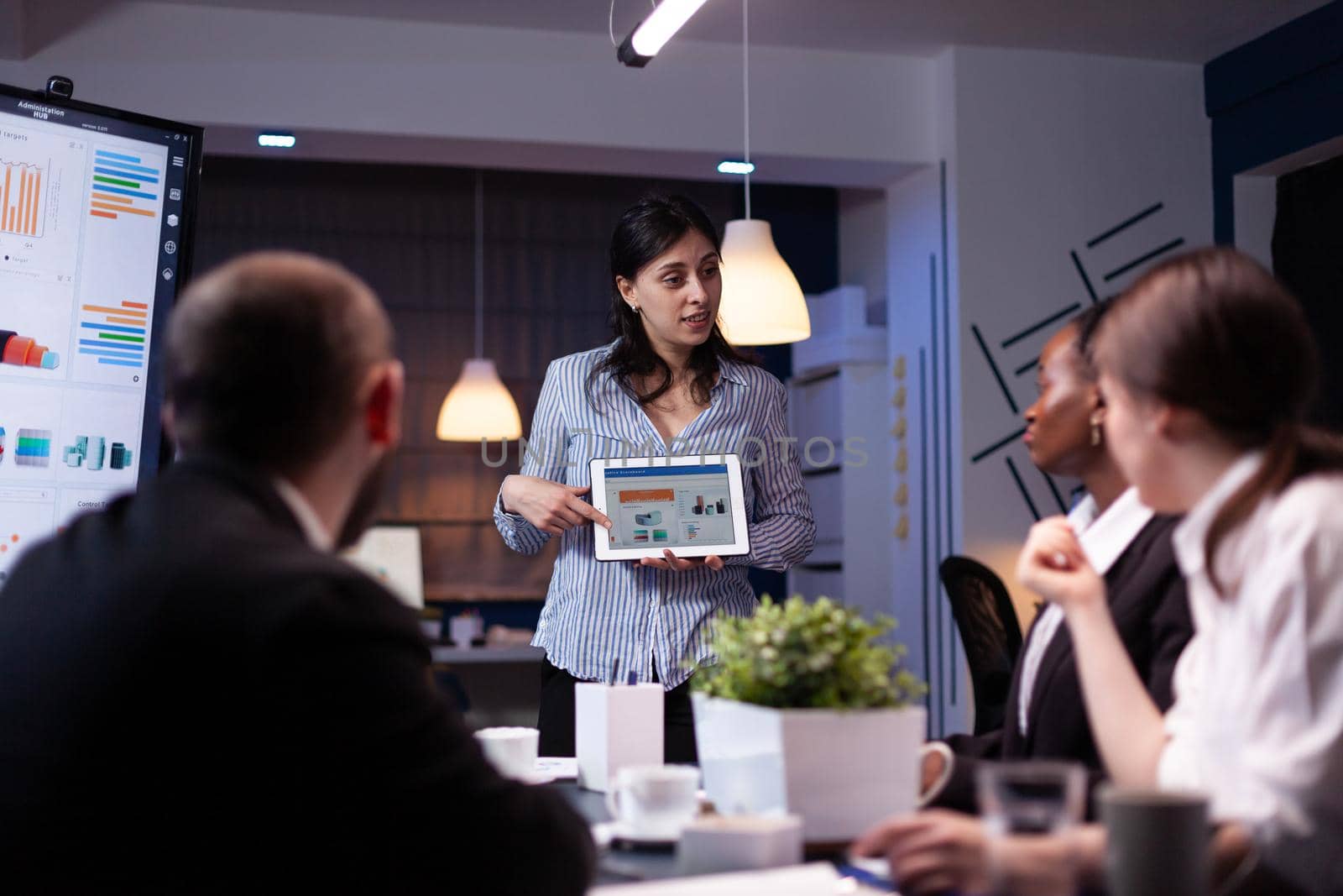 Manager holding tablet pc in meeting room late at night by DCStudio