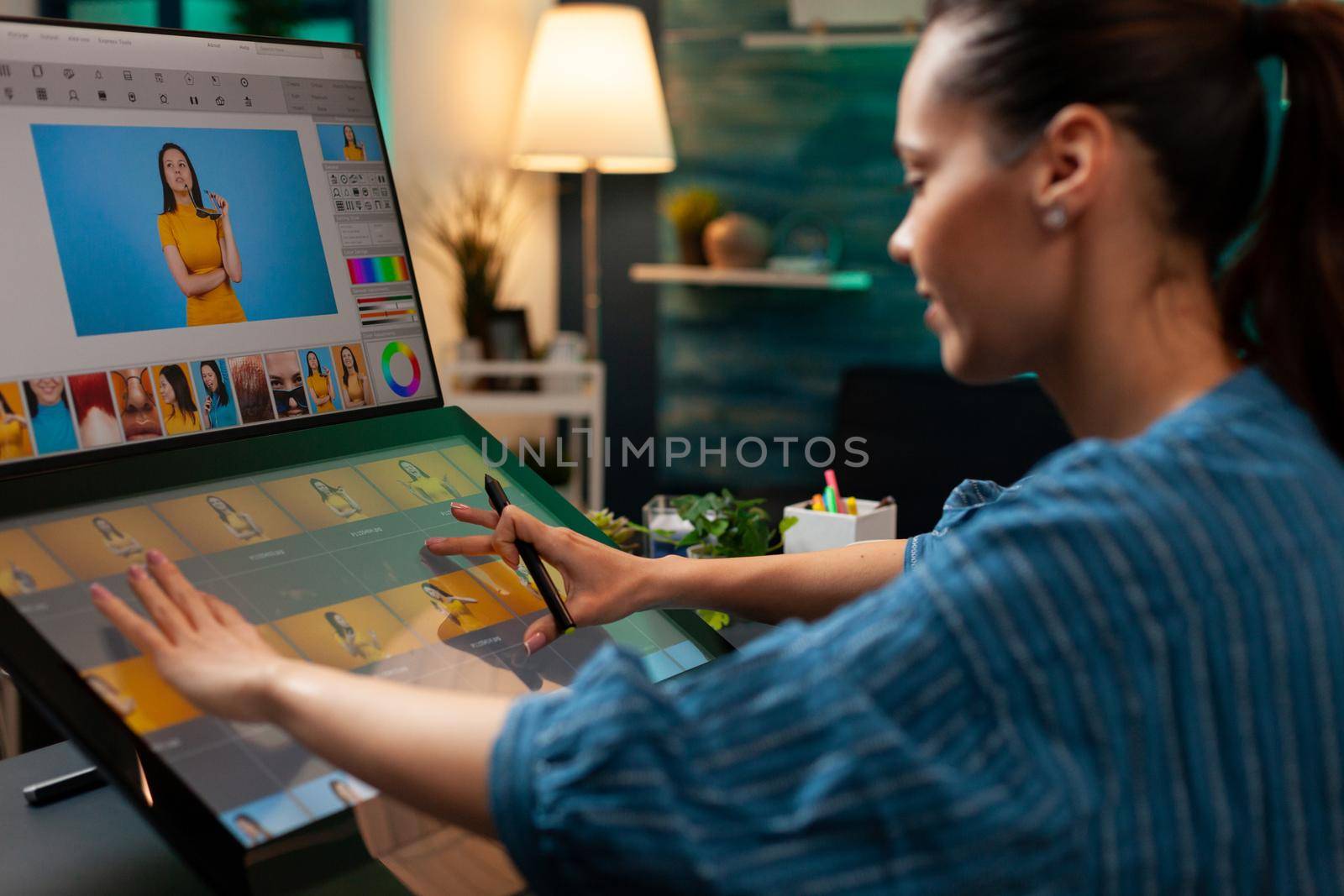 Photo editor artist doing touchpad work on retouching image using stylus and monitor screen for editing design on digital computer. Photographer woman working at production workplace