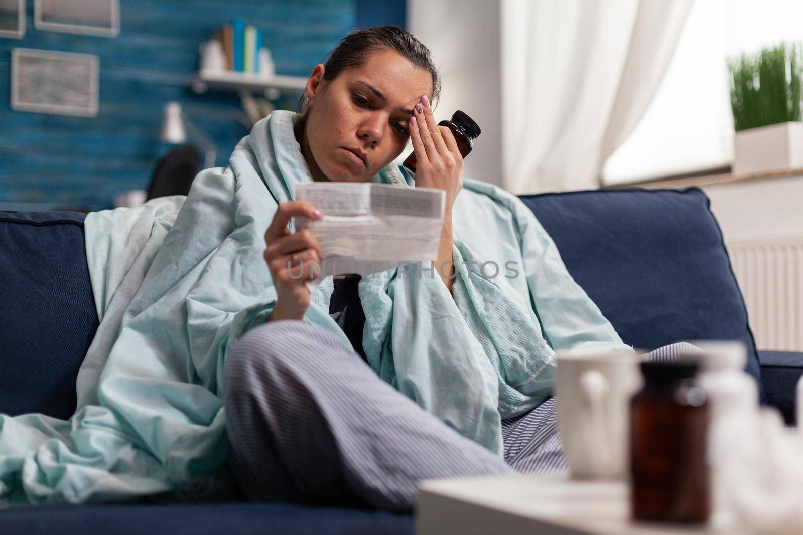 Ill woman holding treatment prescription from doctor or pharmacy to cure disease. Young person with pharmaceutical antibiotics vitamins taking care of illness health headache pain