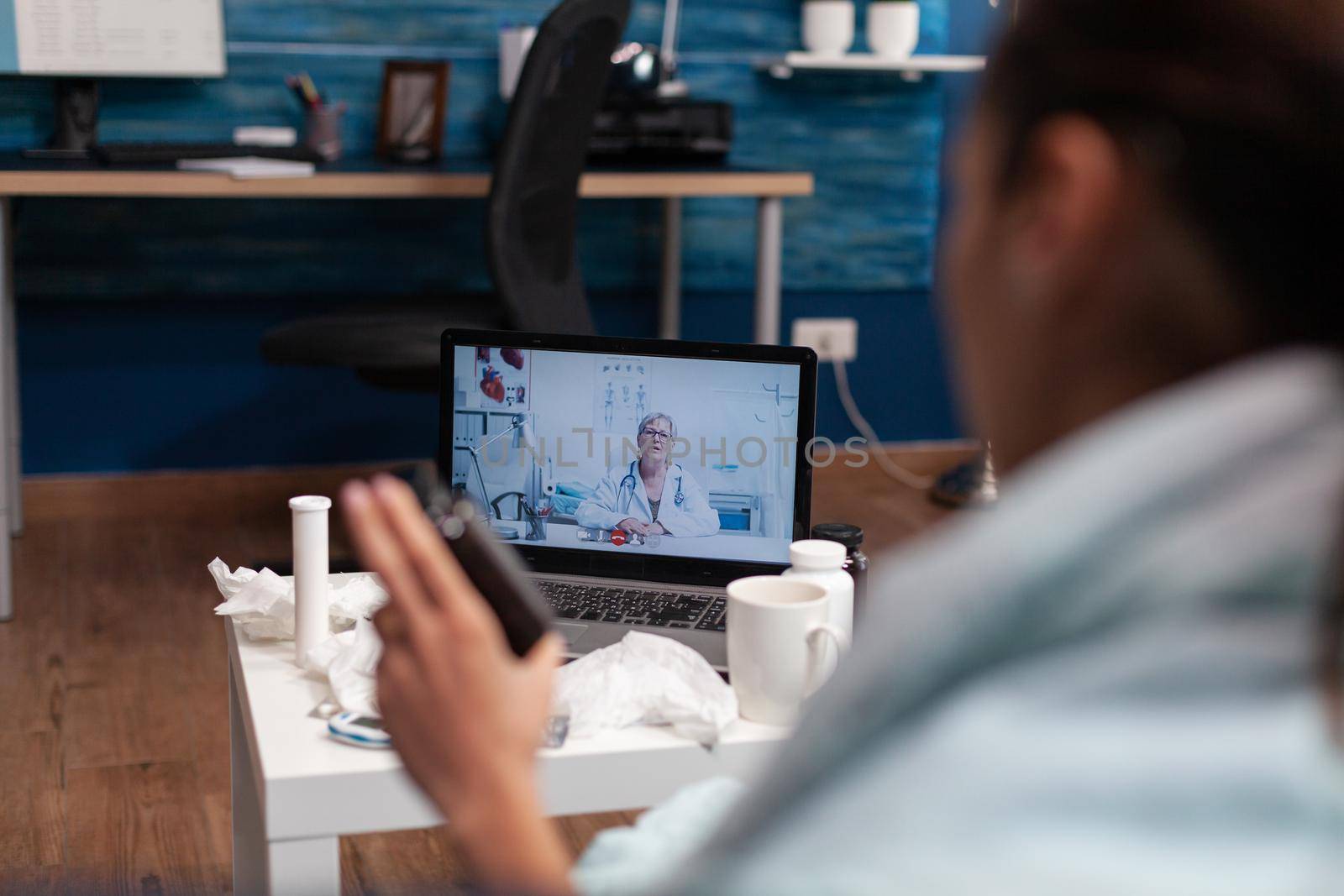 Cold young woman calling doctor from computer by DCStudio