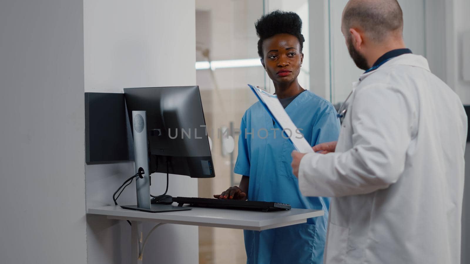 Specialist physician doctor checking sick woman discussing illness treatment while working in hospital ward. Patient sitting in bed explaining symptom disease during recovery appointment