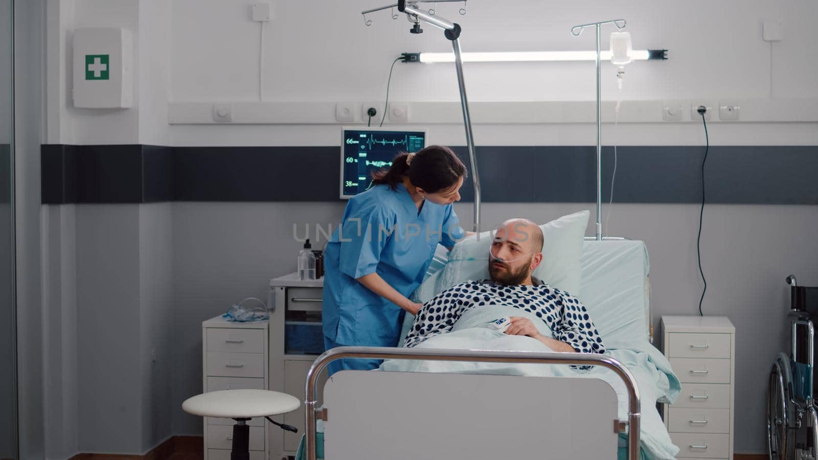 Woman practitioner assistant checking sick man monitoring heartrate pulse by DCStudio