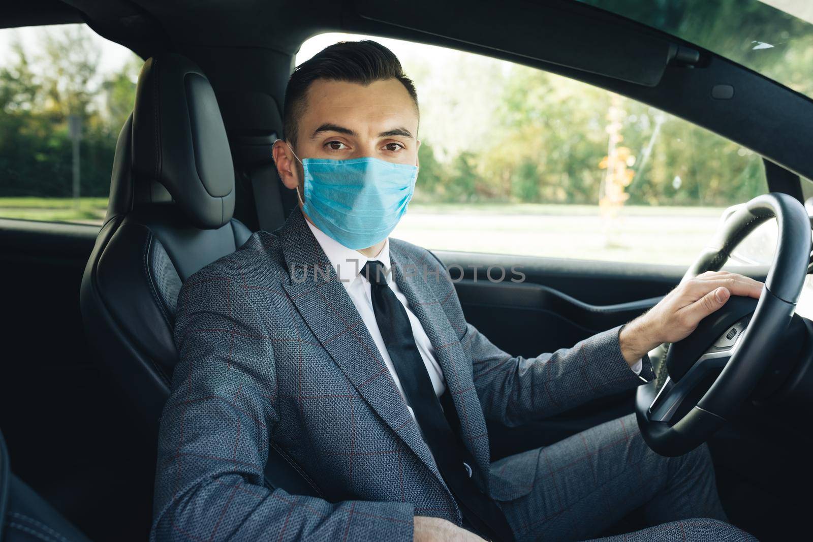 Businessman healthcare. Pandemic. Citizens. Lockdown safety. Businessman wearing medical mask in prevention for coronavirus and driving his car to work. by uflypro