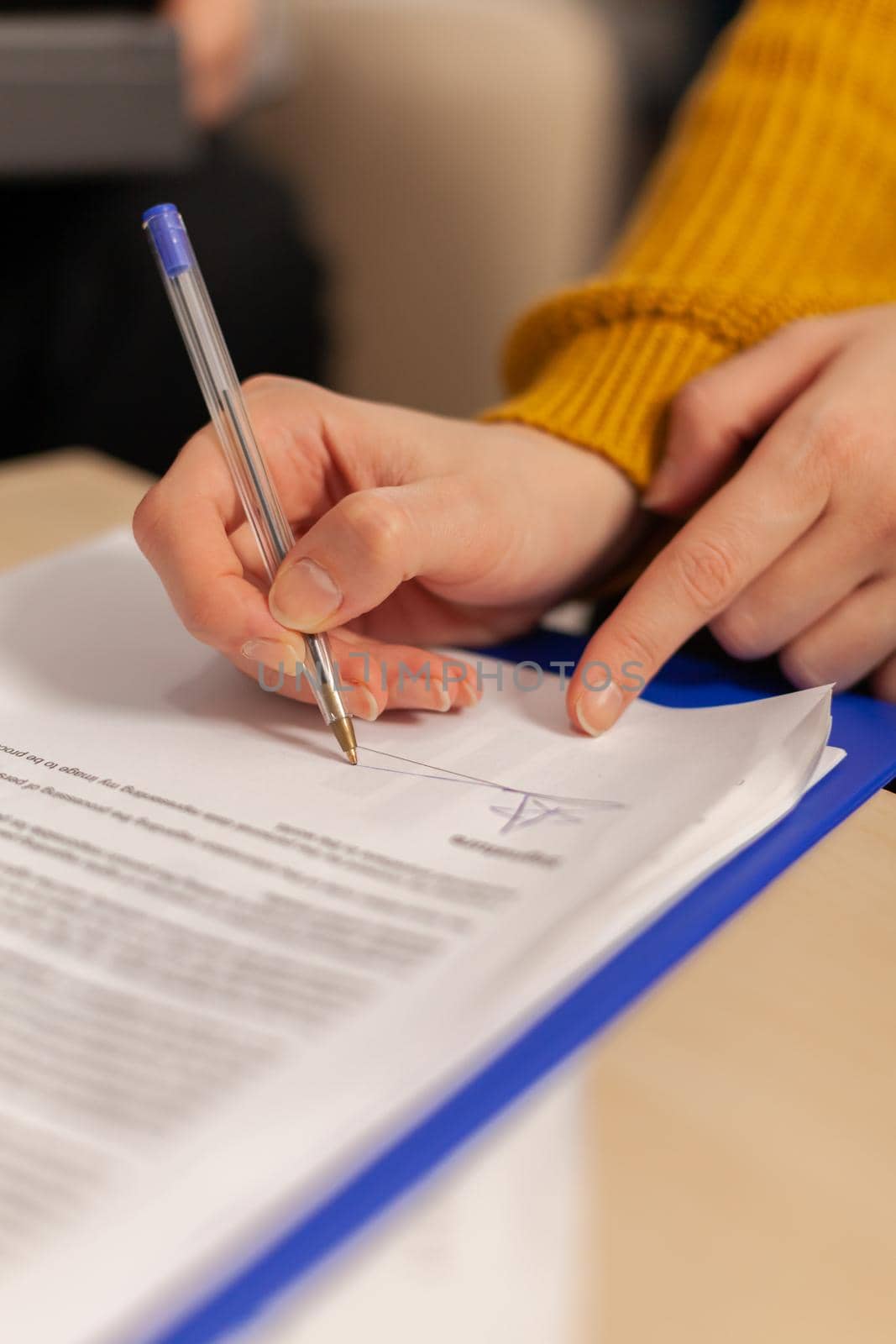 Businesswoman signing paper, partner hand puts signature on document by DCStudio