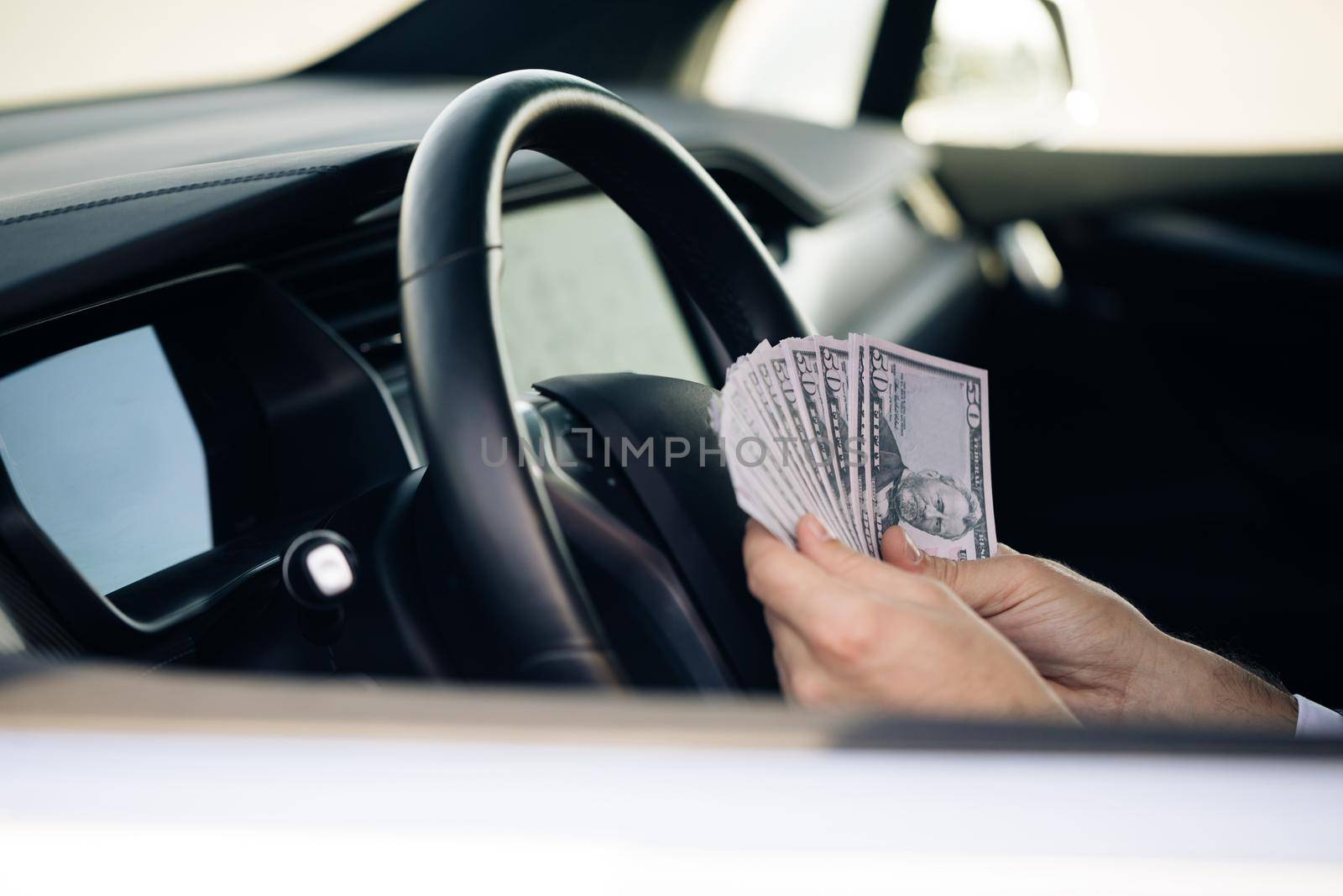 Businessman Counting Money Usd Bills Payday Inside Car. Man sitting with cash money at vehicle.