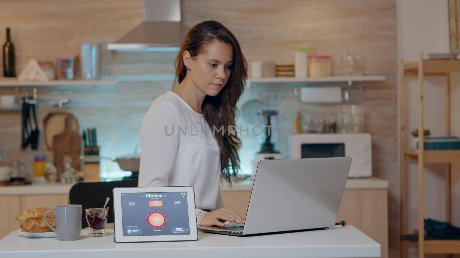 Woman using voice activated smart wireless lighting app on tablet by DCStudio