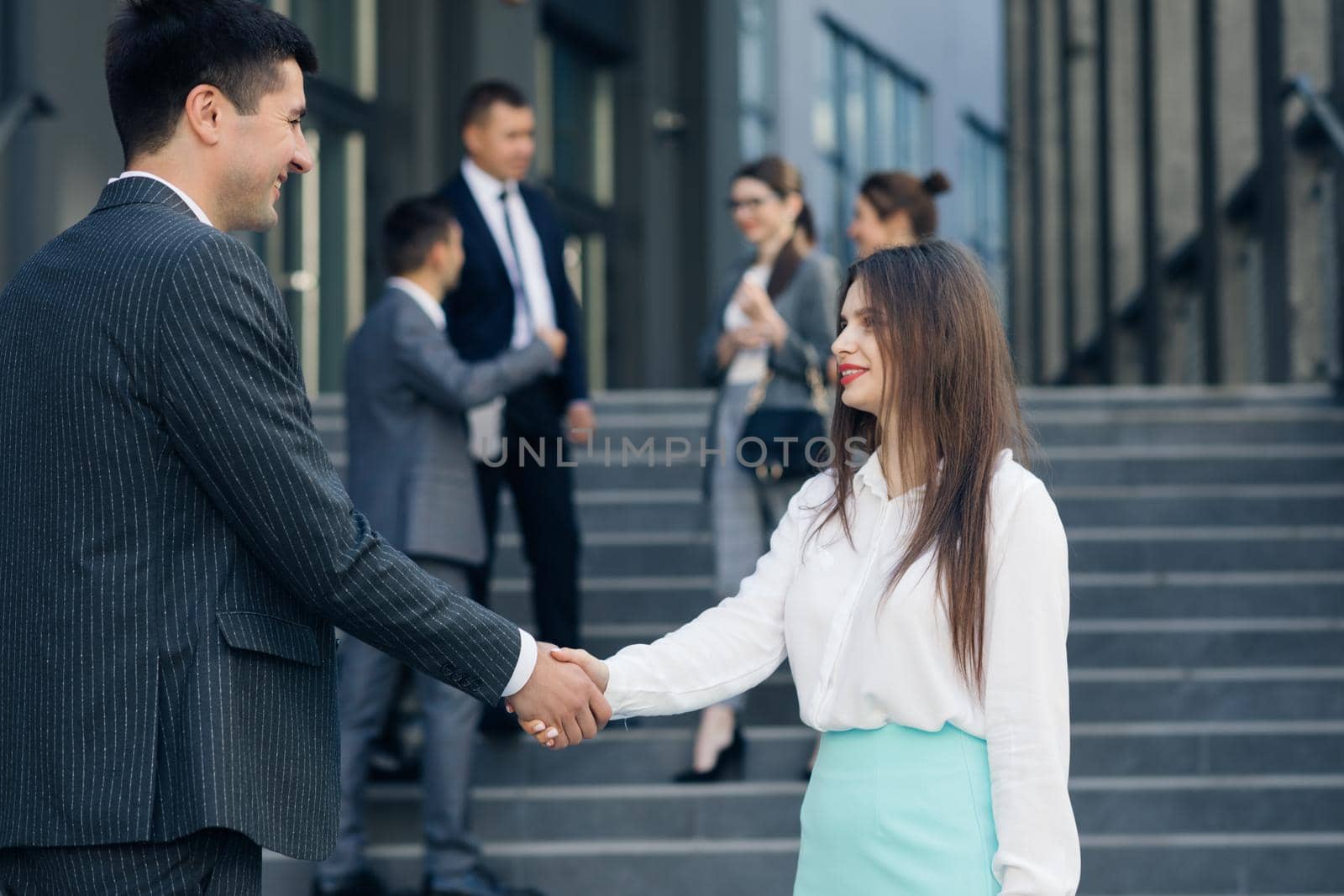 Friendly Handshake Man and Woman. Meeting of Two Business People outdoors. Persons Greeting Each Other. Businessmen shaking hands by uflypro