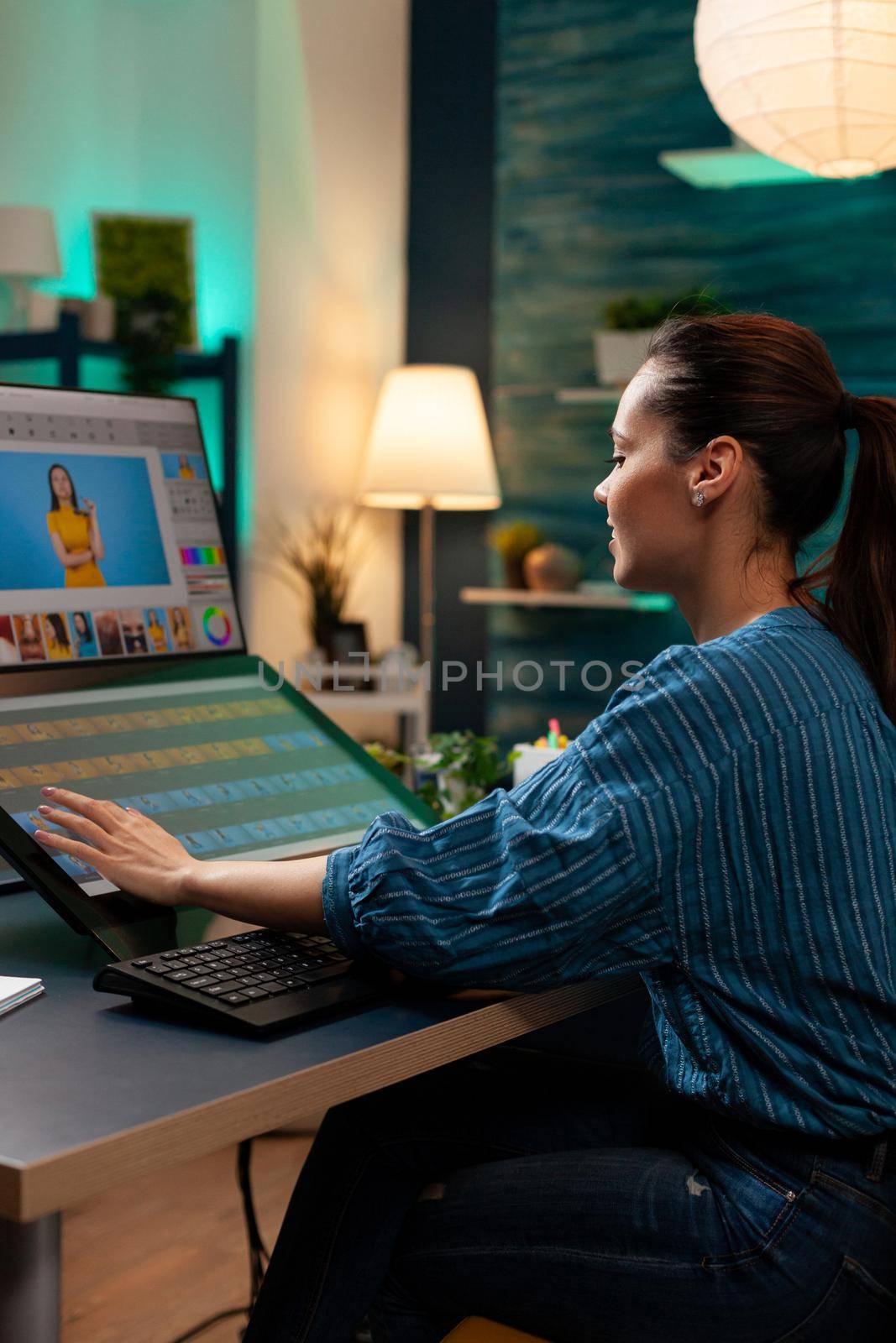 Photo editing specialist working as graphic designer at office doing retouching work on pictures using editor interface, template software. Woman with modern photography equipment