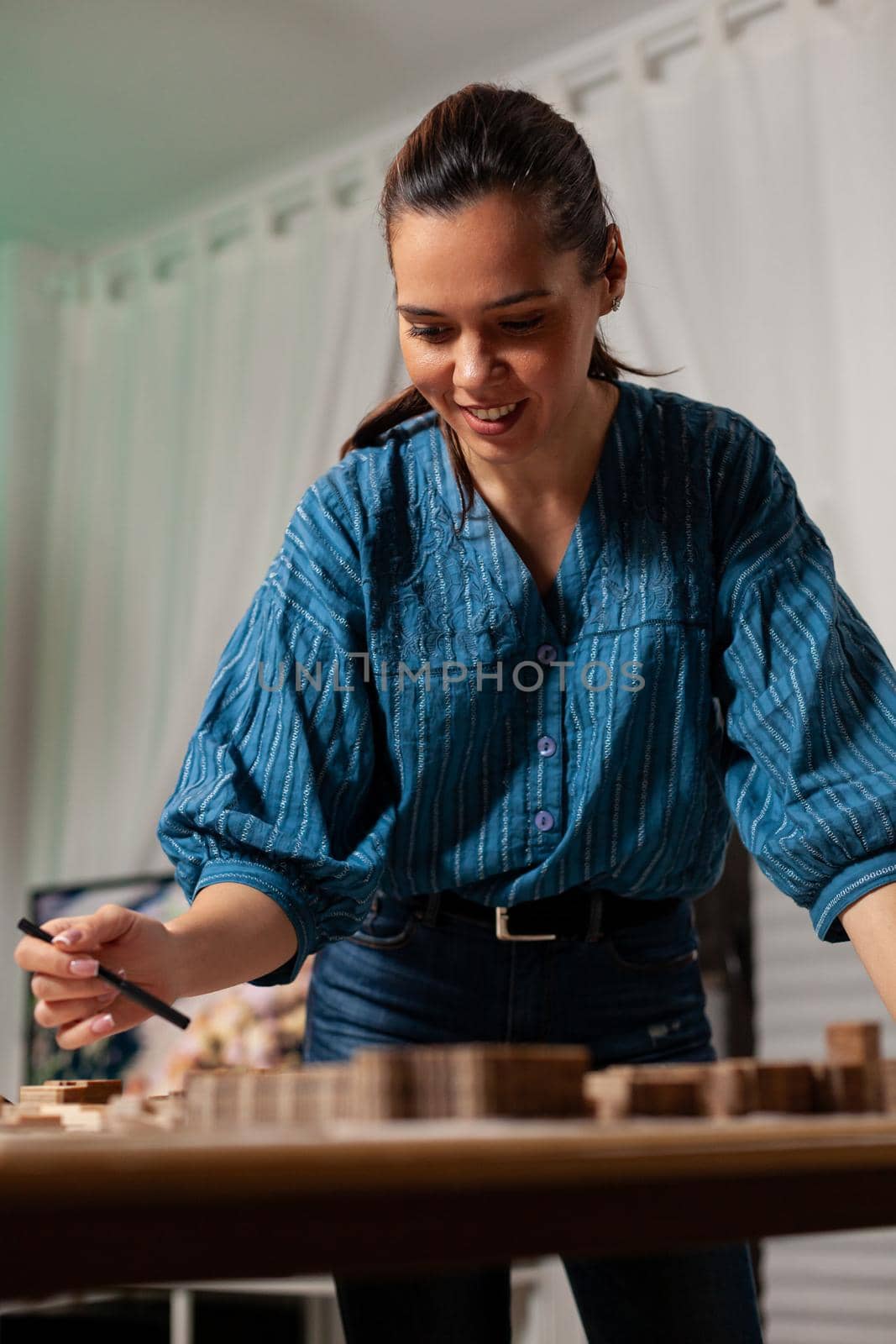 Portrait of architect designer doing construction work at workplace office. Standing woman working with modern tools on table for business building model layout measurement project