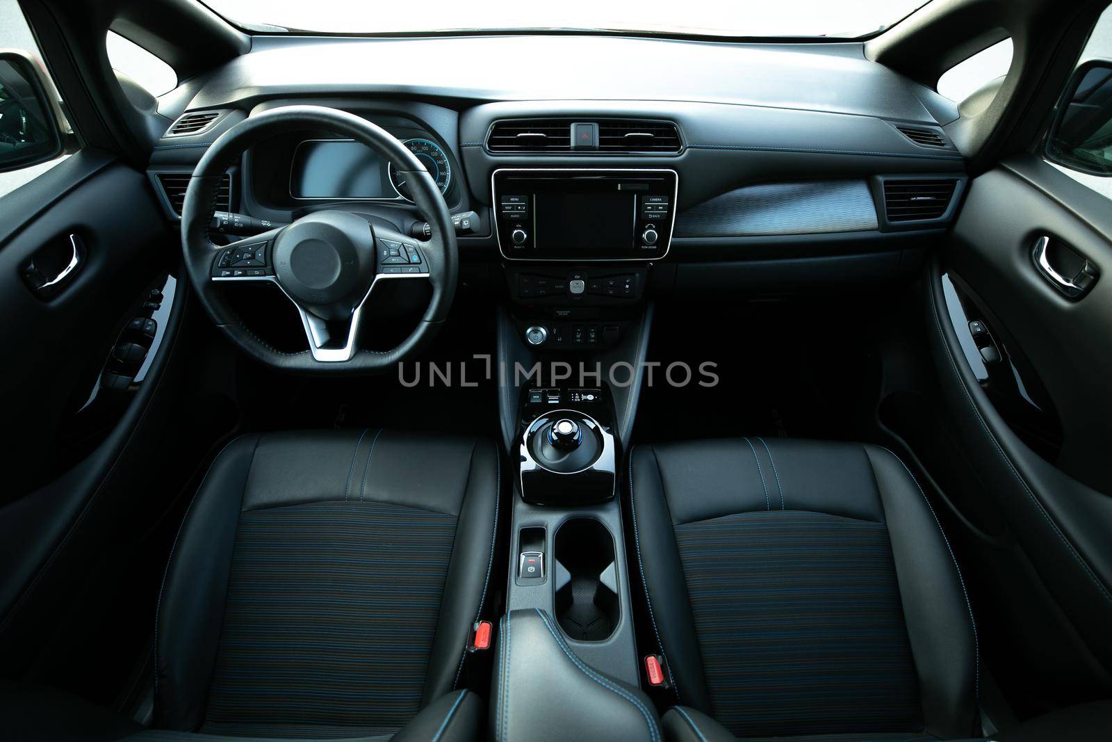 Electric car interior details of door handle with windows controls and adjustments. Inside car interior with front seats, driver and passenger, textile, windows, door panels, console by uflypro