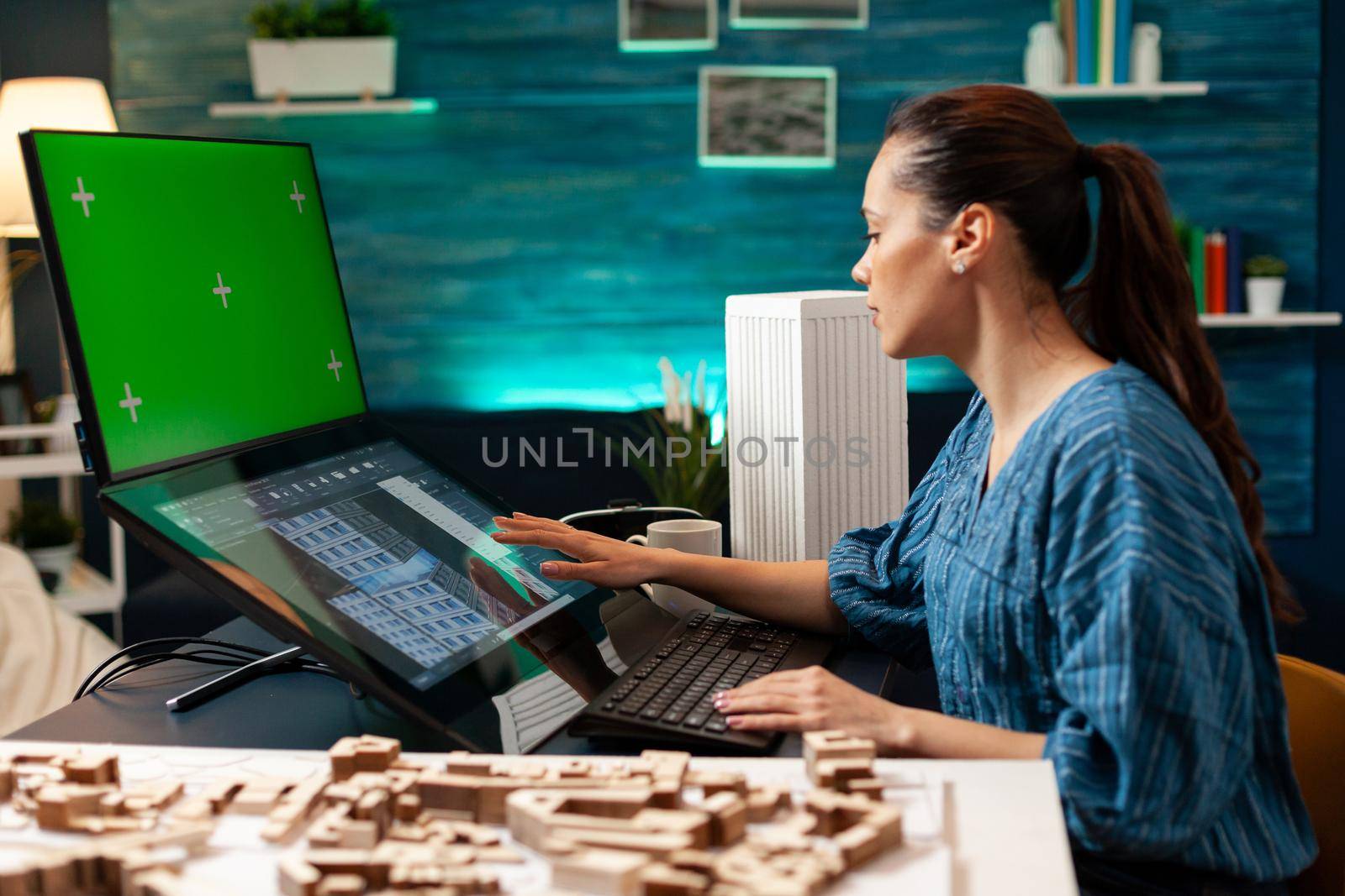 Architecture manager with design plan and green screen on computer monitor using professional equipment and tools. Woman working on blue print with isolated mockup background chroma key
