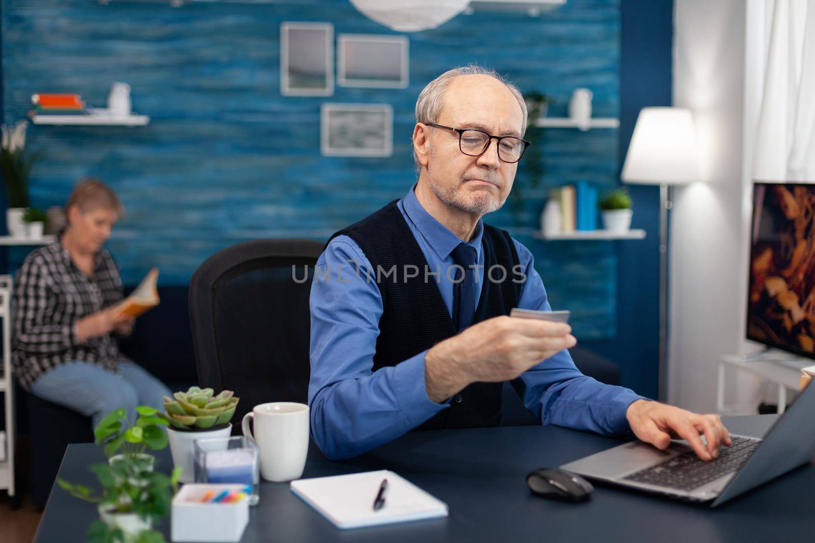 Senior man reading cvv conde on credit card by DCStudio