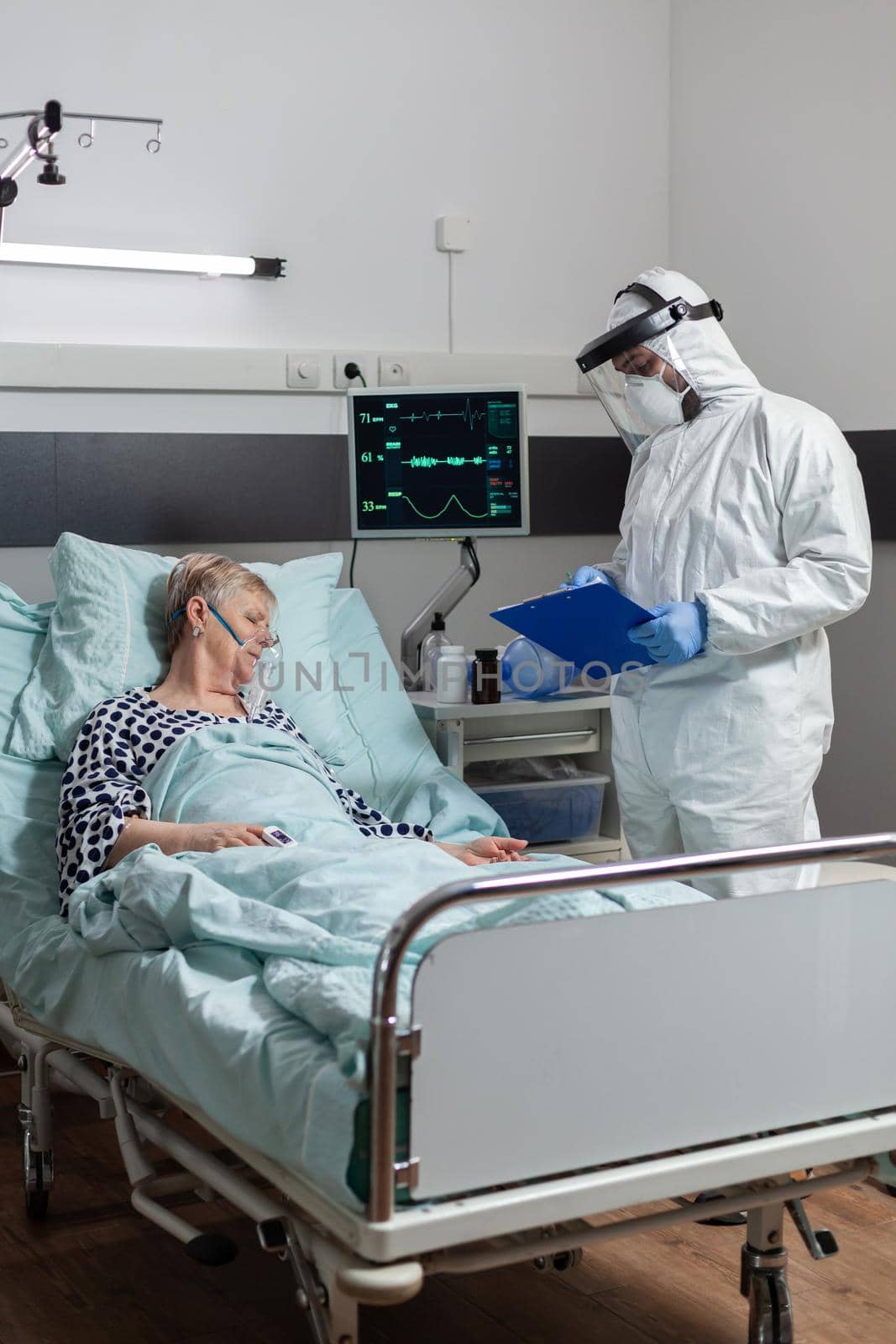 Senior woman patient laying unconscious in hospital bed by DCStudio
