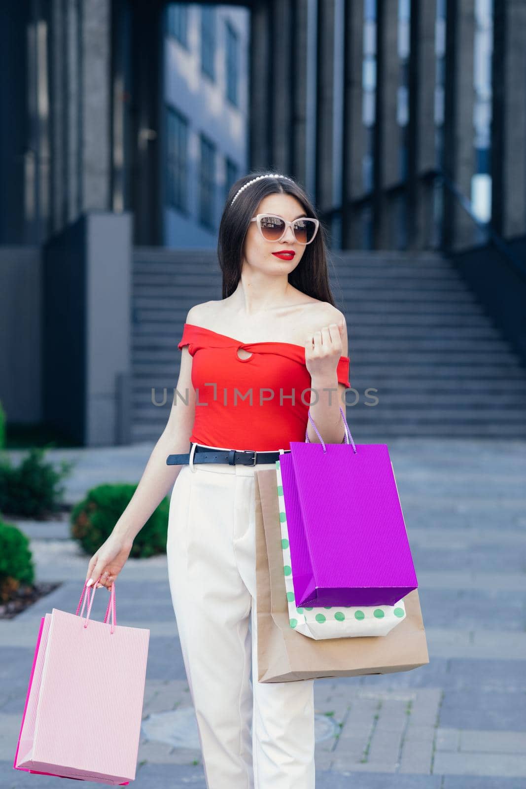 Young Girl with colorful shopping bags walking around the city after shopping. Consumerism, purchases, shopping, lifestyle concept by uflypro