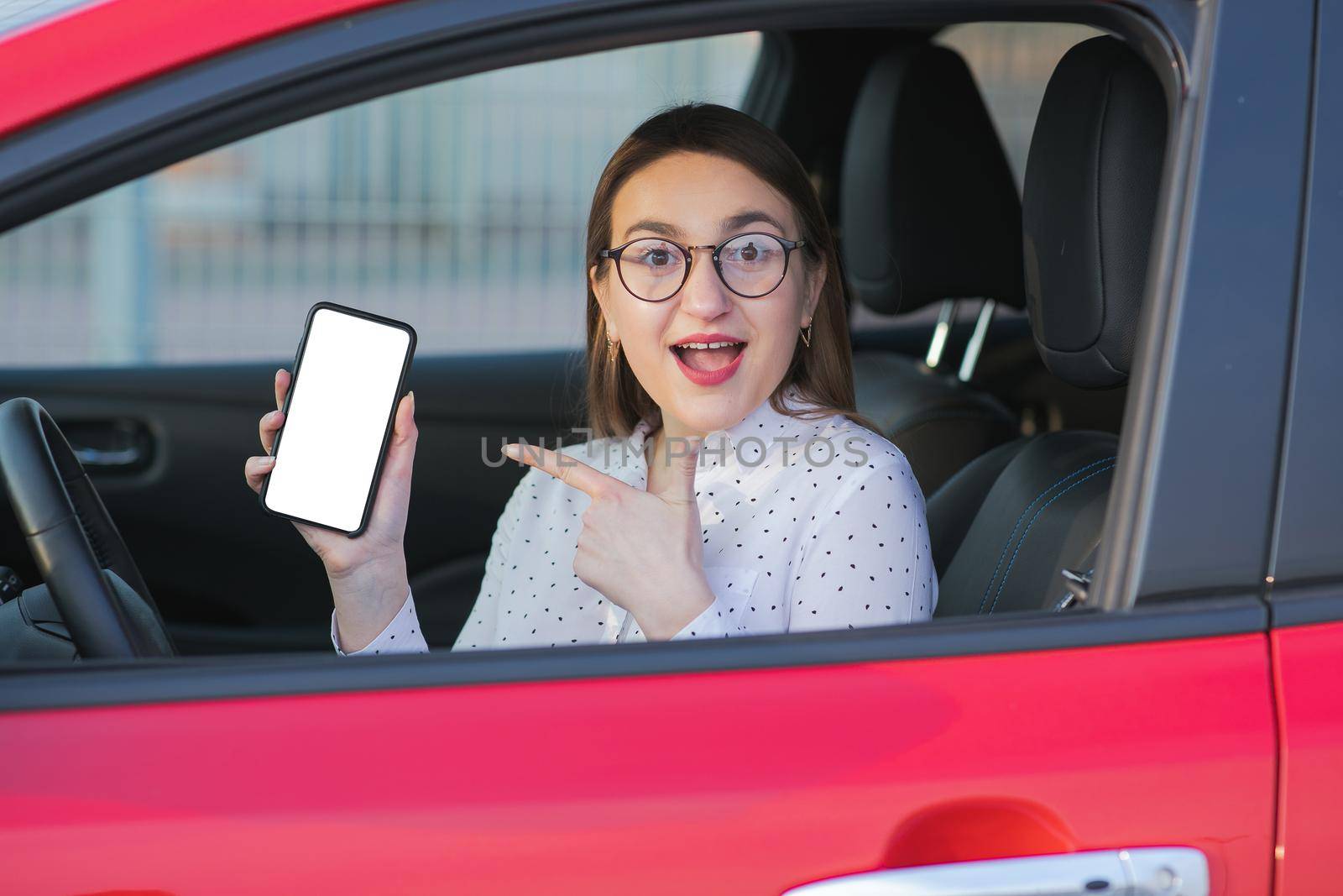 Charging Electric car and Looking at App On Mobile Phone. Close up of smartphone screen. Hand holding smart device with white display. Mobile application for eco transportation.