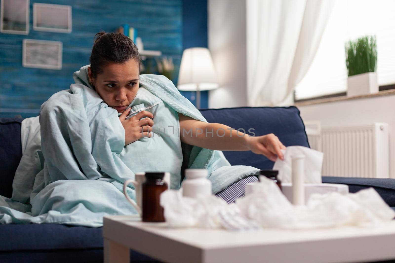 Woman with flu symptoms sitiing at home ill by DCStudio