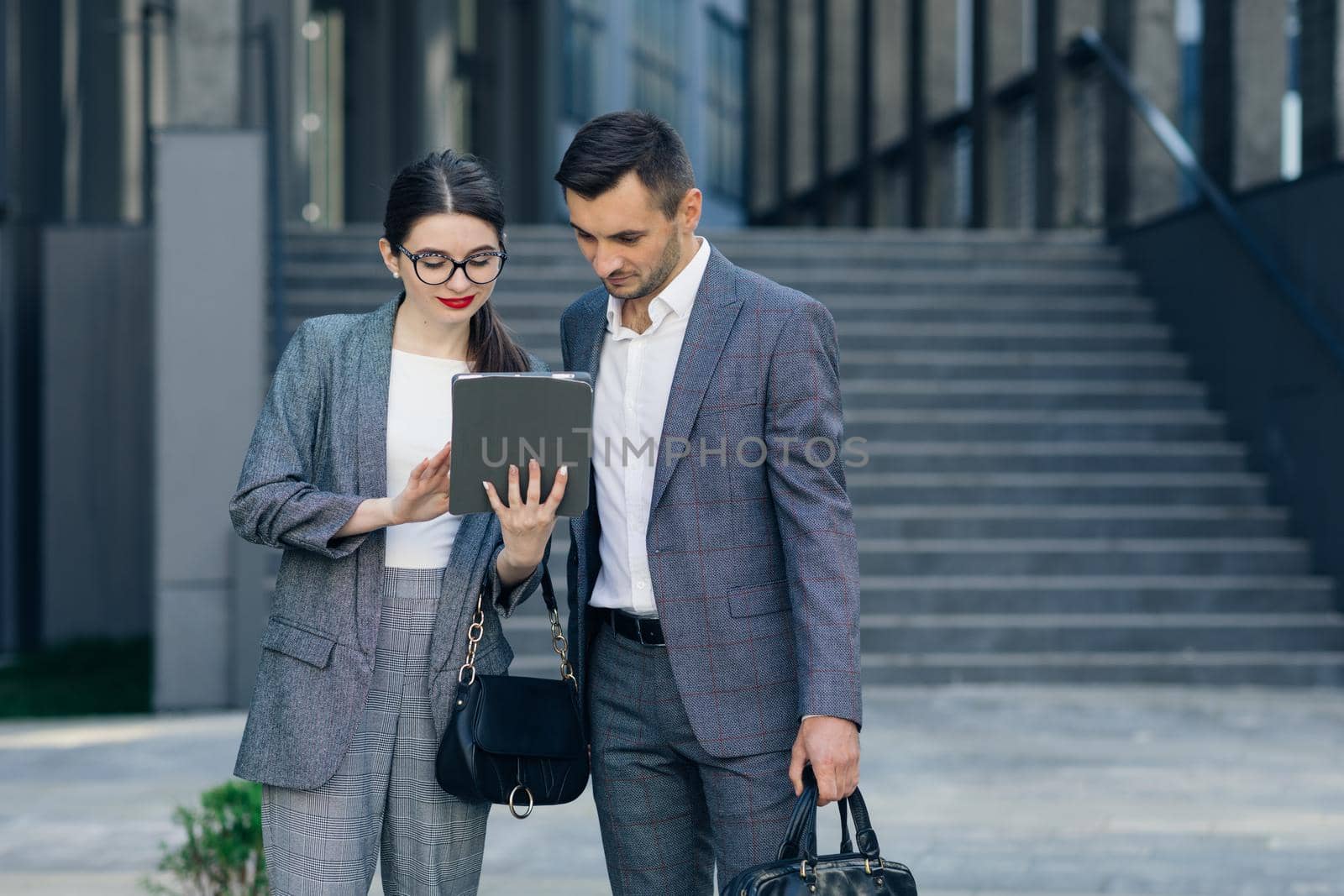 Office workers looking at tablet computer. Young business people discussing over a tablet. by uflypro