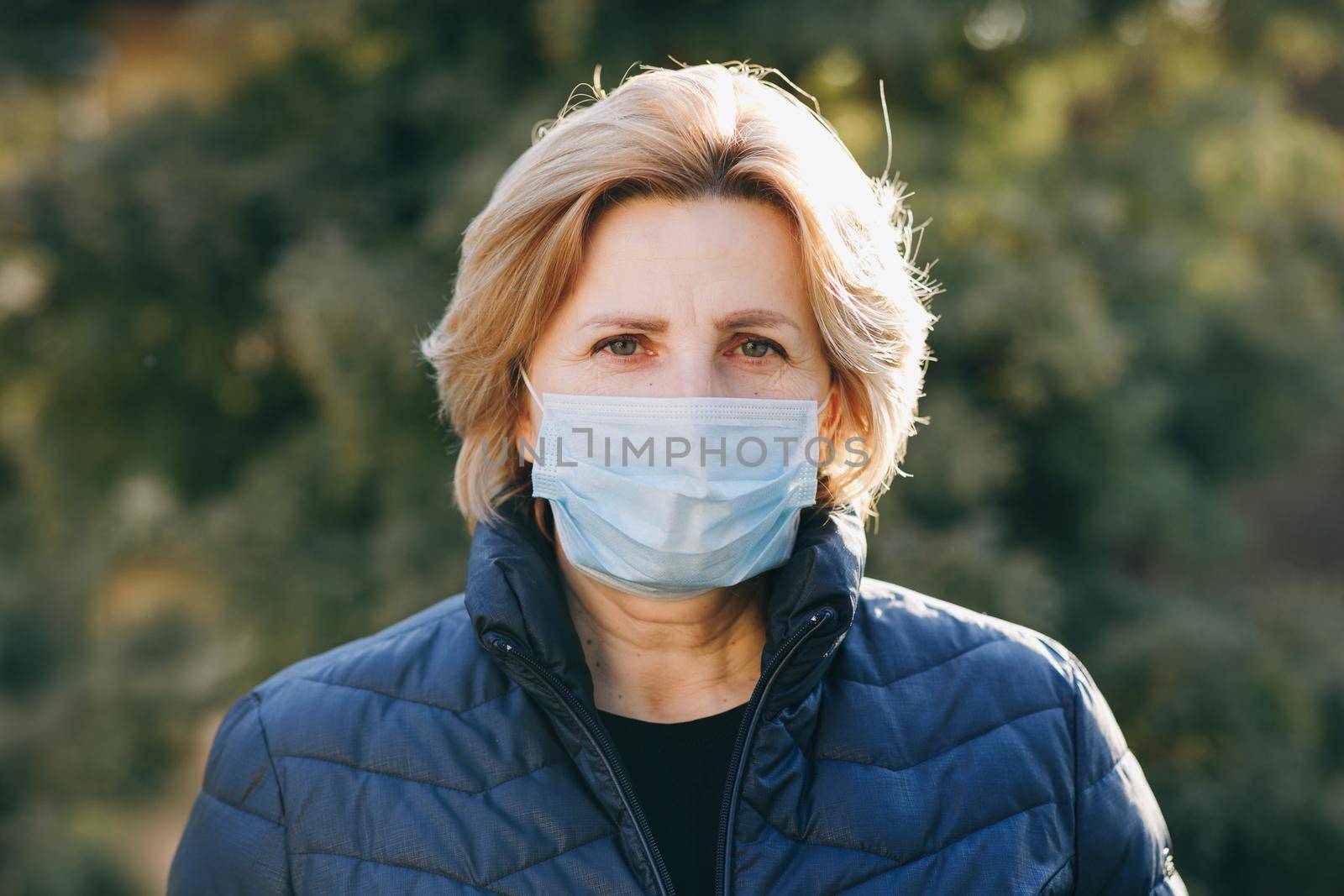 Woman Wearing Medical Mask During Coronavirus COVID-19 Epidemic. Sick woman wearing protection during pandemic. Pretty Caucasian Woman Taking on Medical Mask Outdoor by uflypro