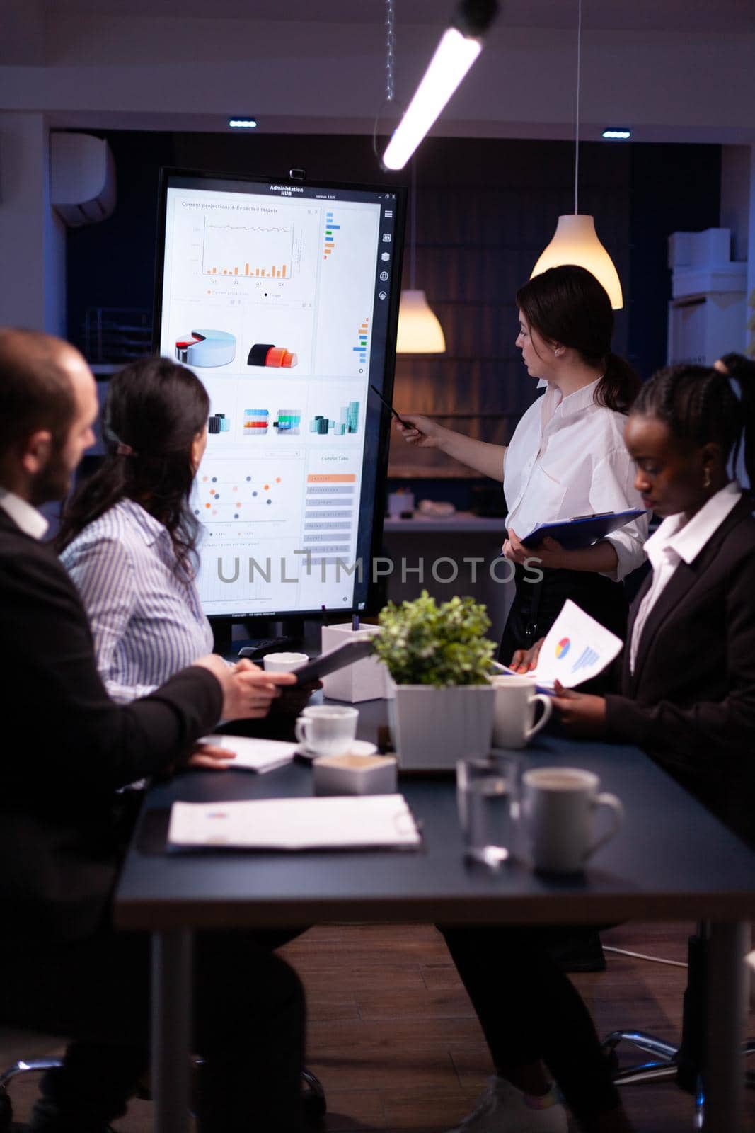 Diverse multi ethnic business teamwork overworking in office meeting room analyzing financial graphs by DCStudio
