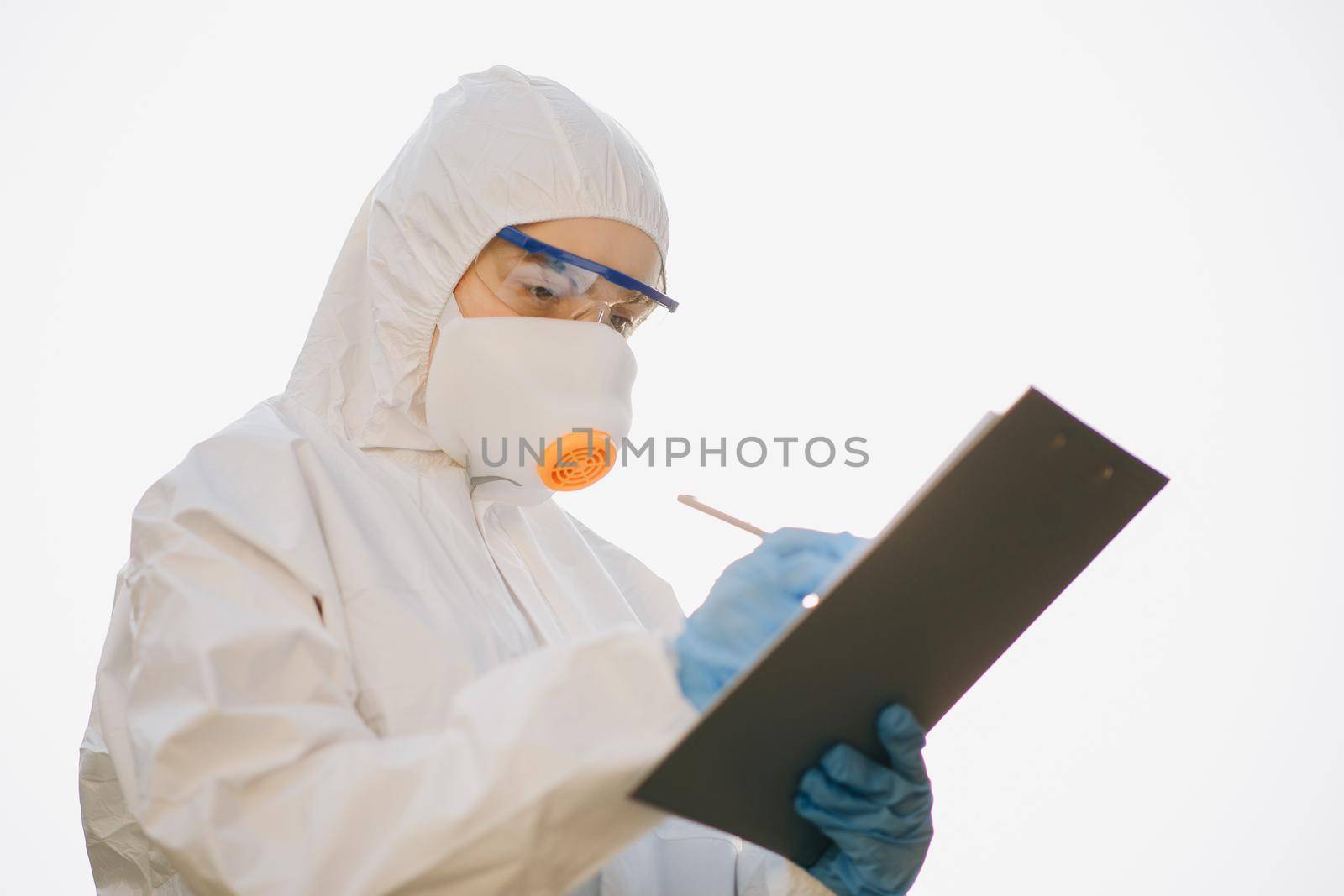 Worker in chemical protective suit. Successful chemist in a suit posing on a white background isolated. Doctor epidemiologist fighting with coronavirus COVID-19.