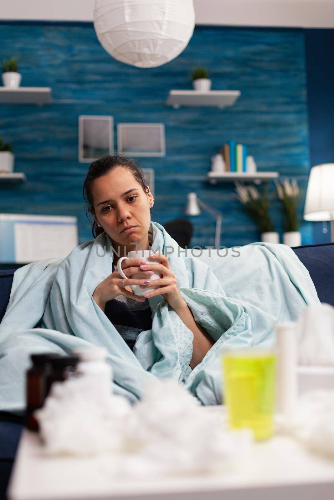 Sick caucasian woman sitting in bed with severe cold and flu by DCStudio