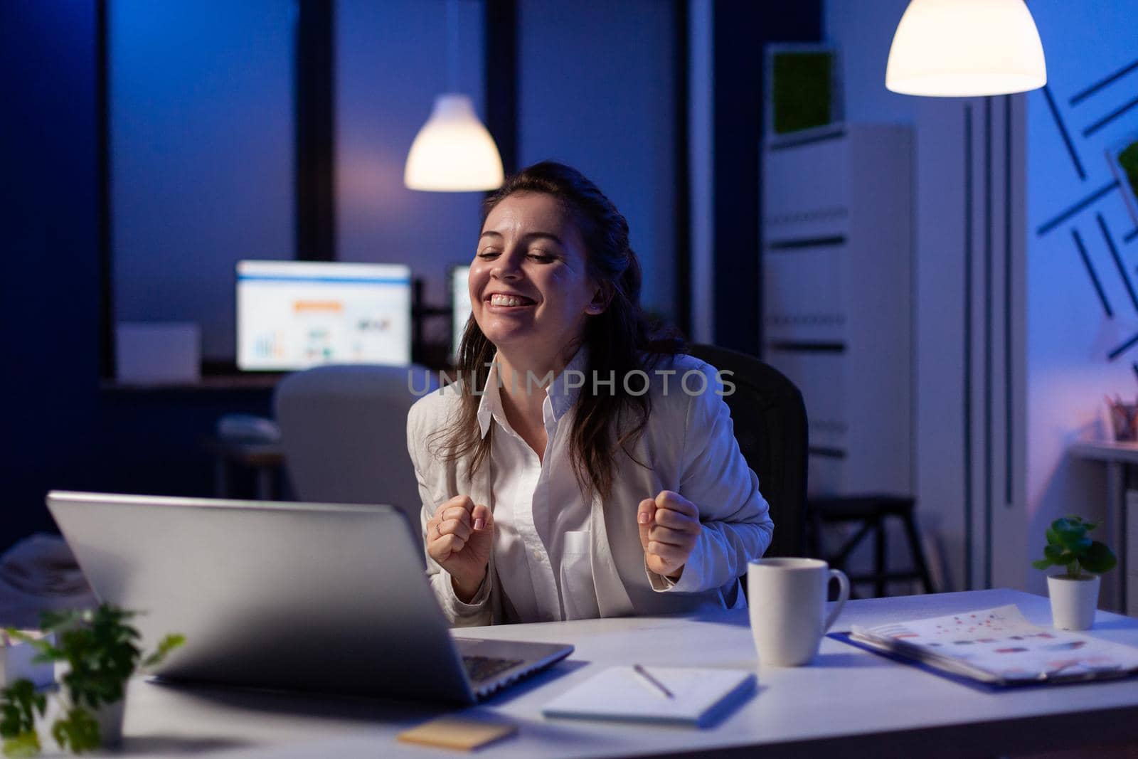 Happy businesswoman reading great online news on laptop working on economic opportunity at start up company office. Employee using modern technology network wireless studying financial statistics