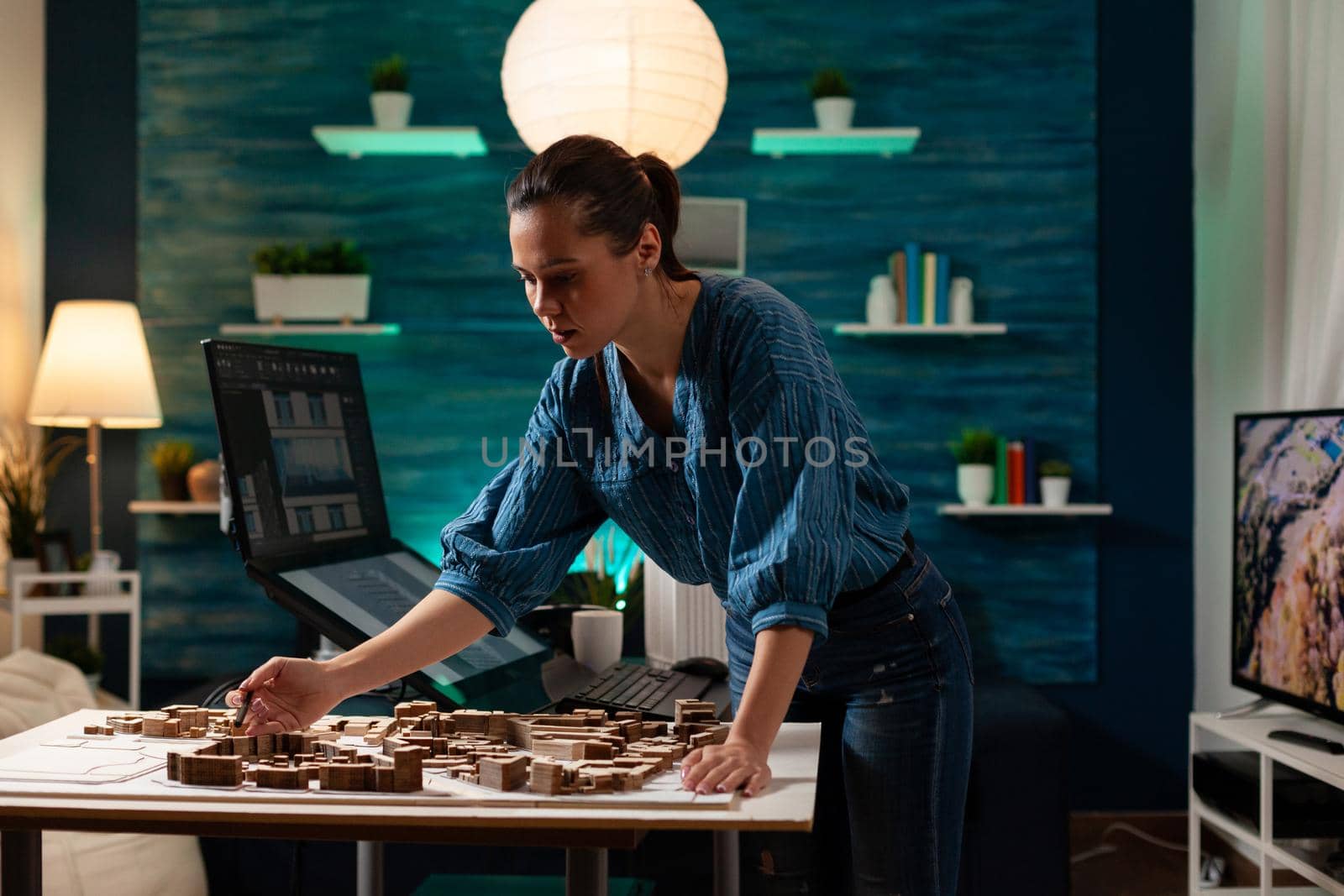 Modern caucasian engineer standing at table analyzing maquette layout building model plan for construction project. Architect woman designing professional renovation property view