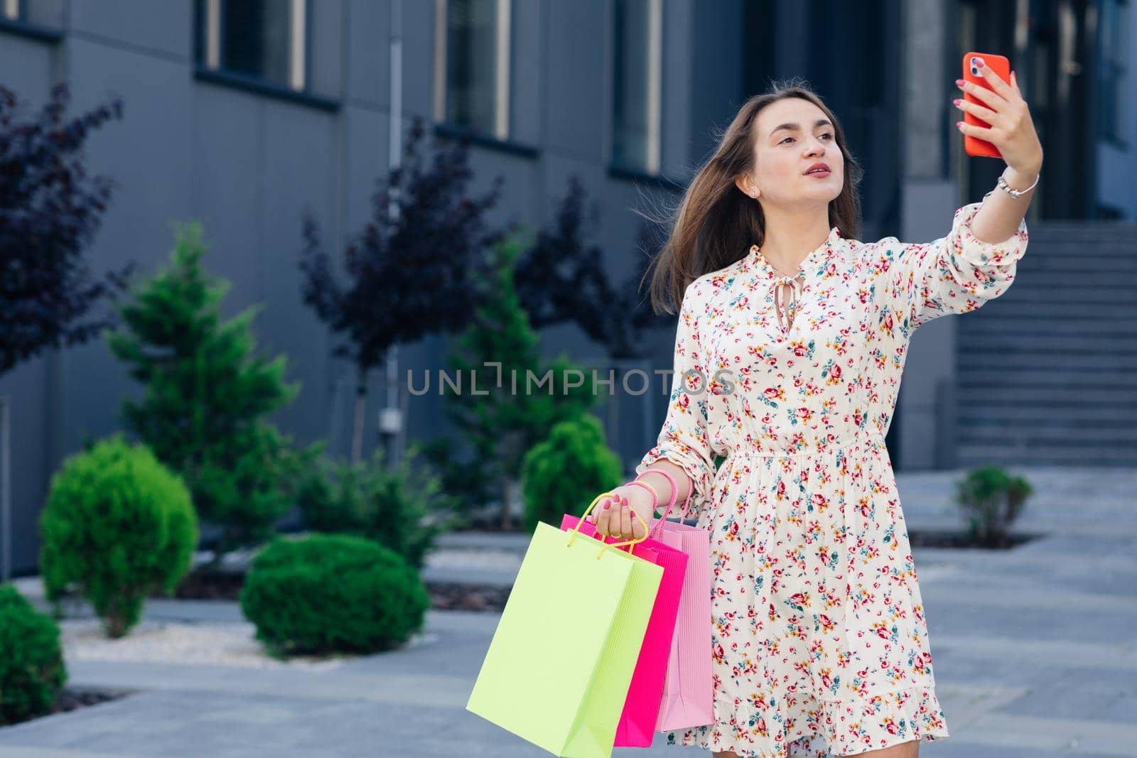 Happy girl making selfie with mobile smartphone outdoor. Social influencer woman having fun doing shopping. Concept of new generation youth lifestyle people and technology