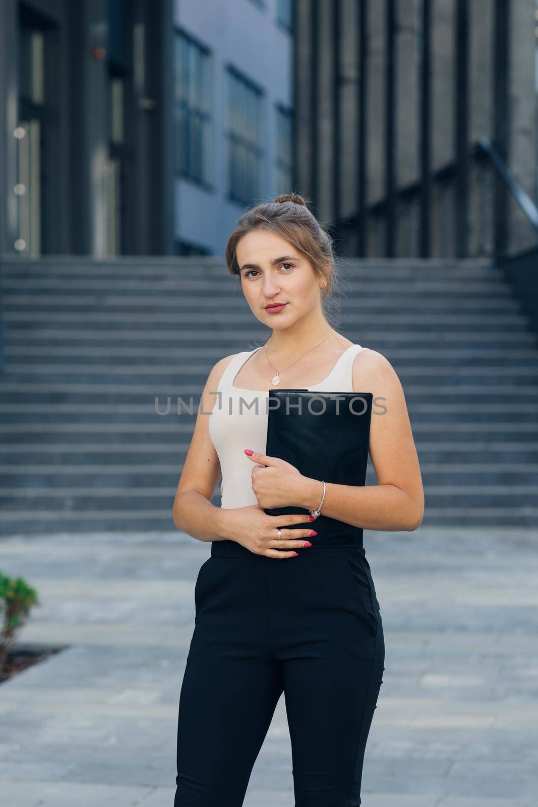 Successful businesswoman standing outdoors near office building. Portrait of a young businesswoman