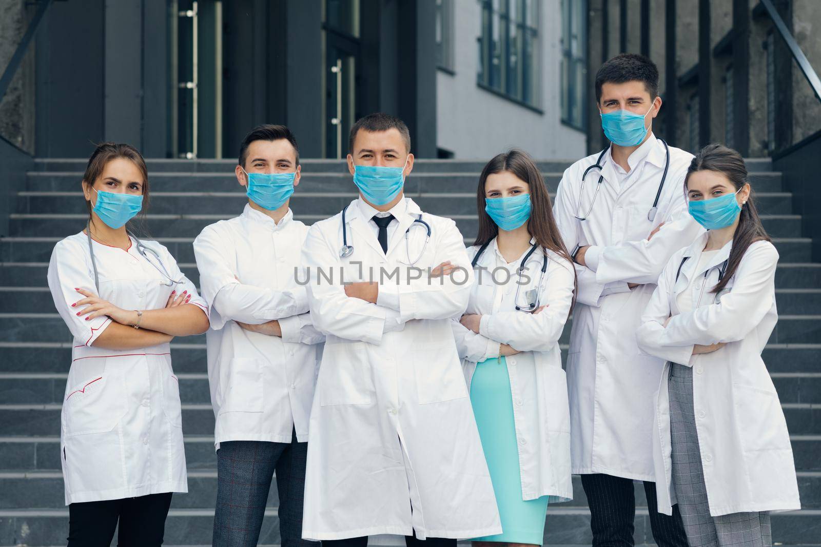 Group of Doctors With Face Masks Looking at Camera. Teamwork Specialist Doctors . Corona Virus and Healthcare Concept by uflypro
