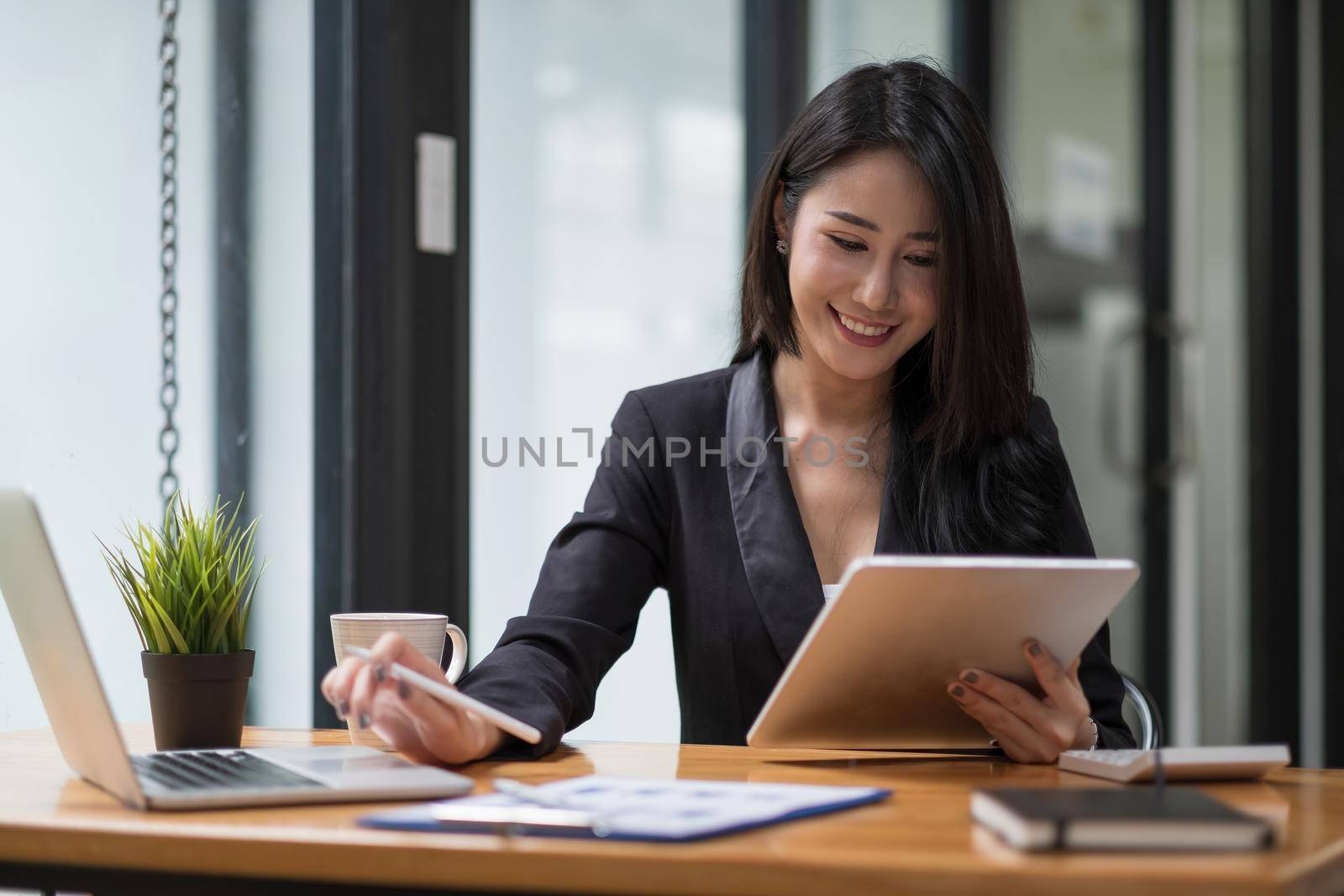 shot of business woman working for financial accounting with laptop and digital tablet.