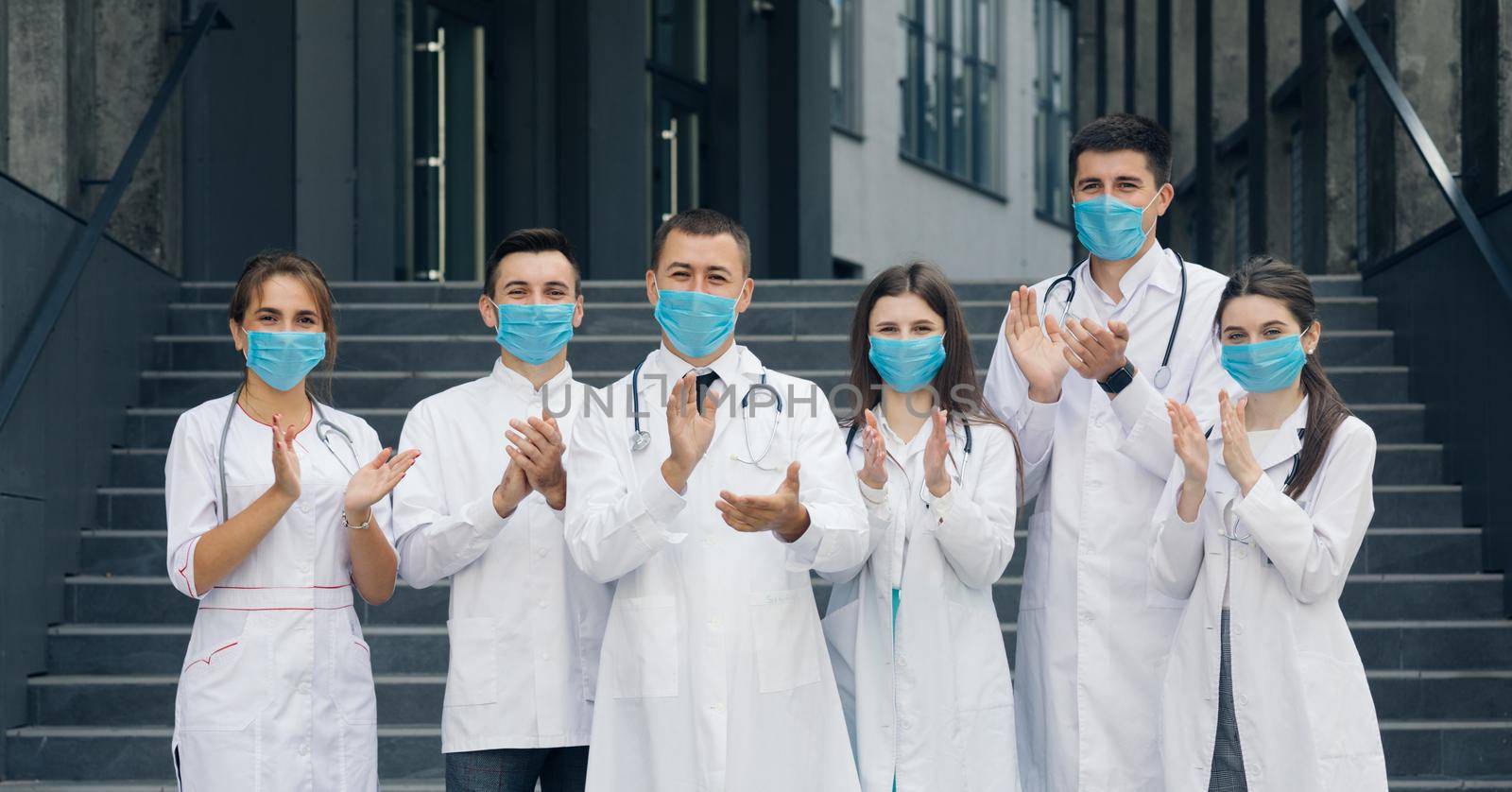 Corona Virus and Healthcare Concept. Medical staff from the hospital who are fighting coronavirus applaud back the people for their support. Group of doctors with face masks looking at camera