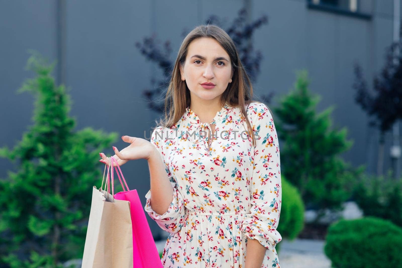 Beautiful young woman with colored shopping bags. Portrait of elegant gorgeous young brunette shopper by uflypro