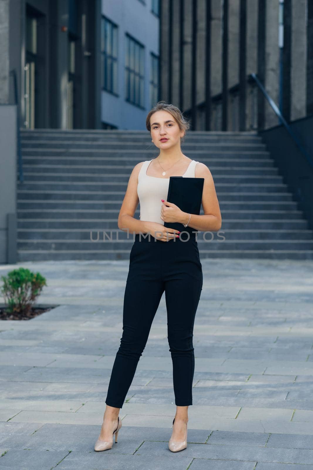 Full lengt portrait of Successful businesswoman standing outdoors near office building. by uflypro