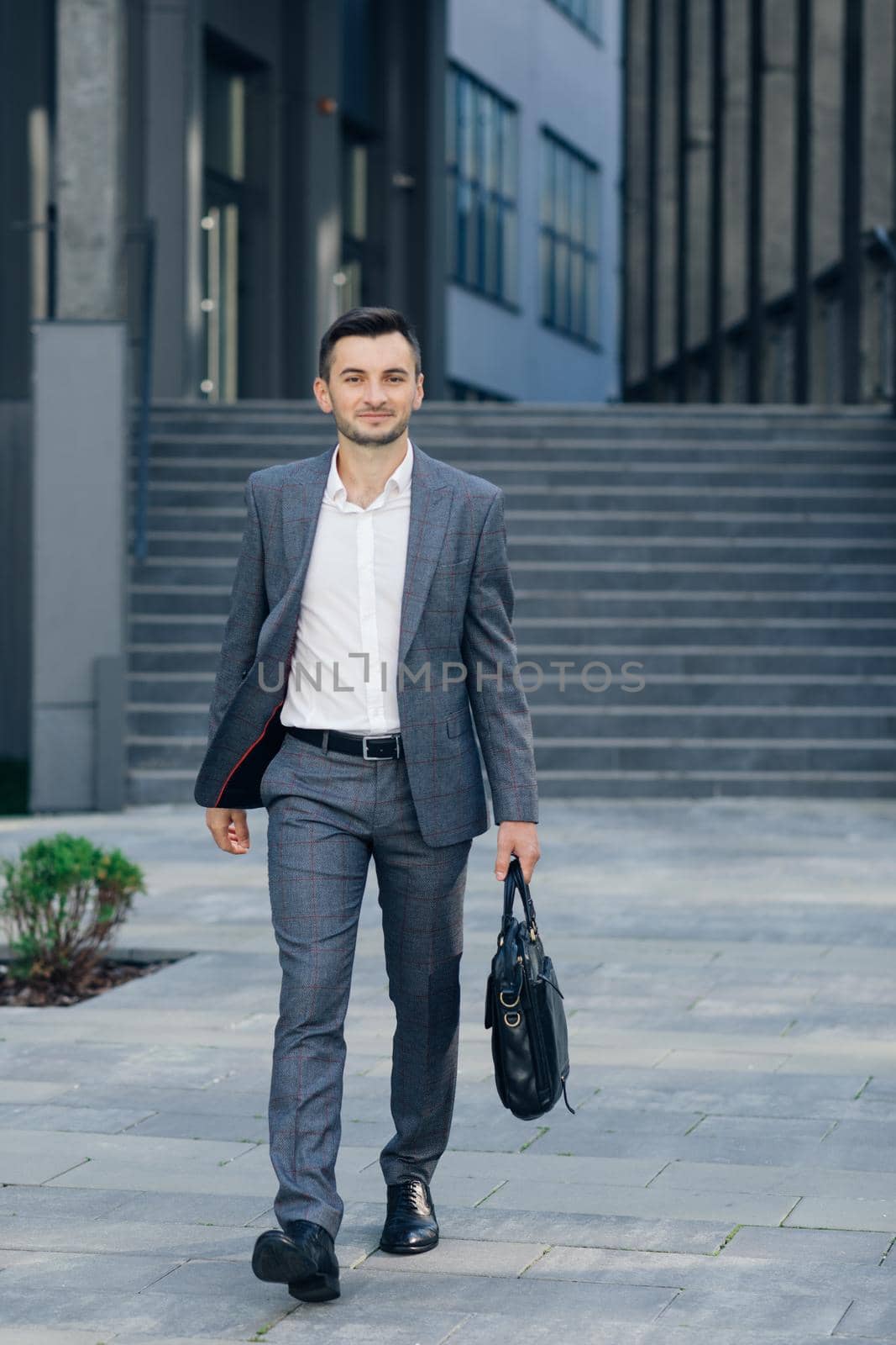 Businessman with suitcase. Full length of confident young businessmen in carrying a suitcase. by uflypro